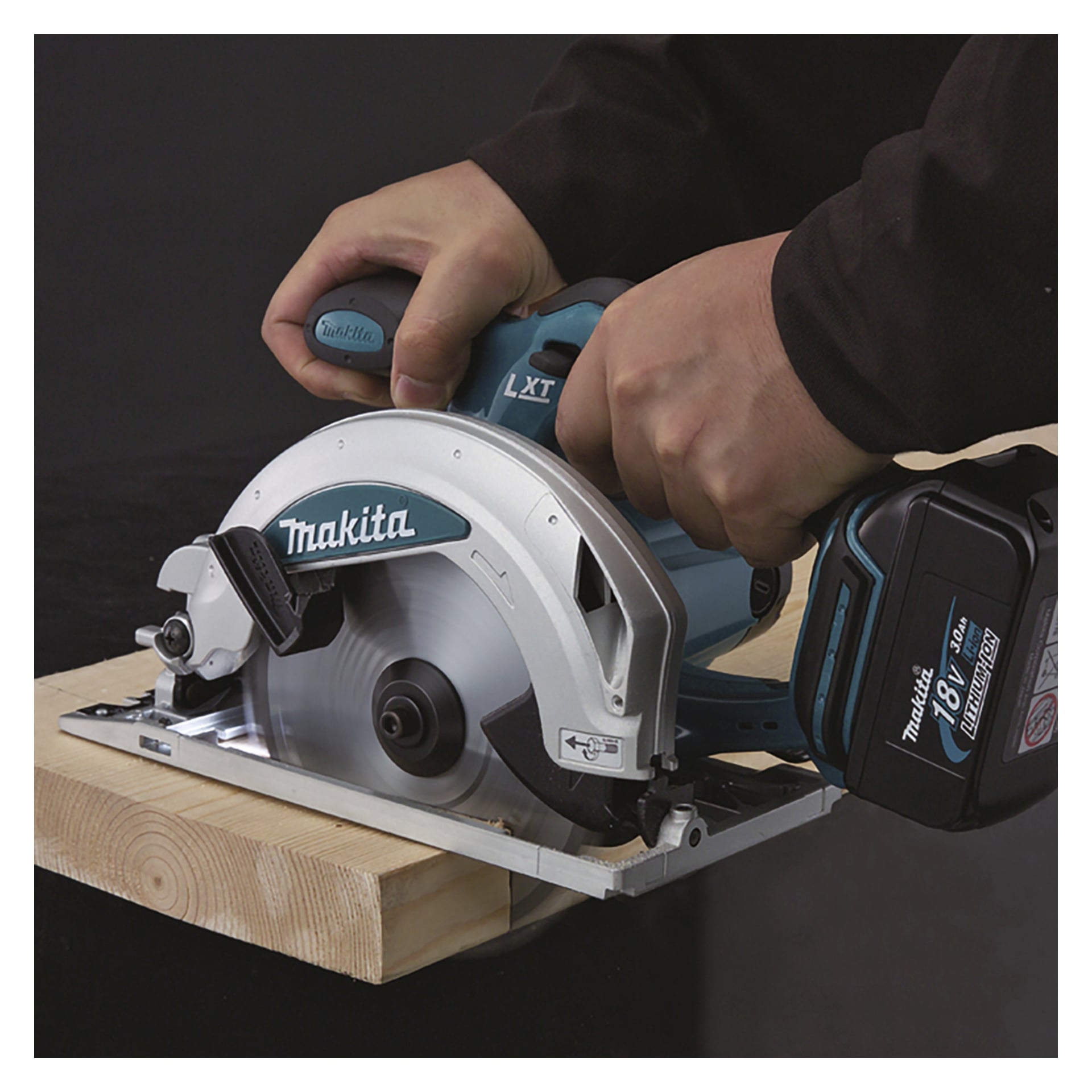 Man håller en Makita sladdlös cirkelsåg med båda händerna och skär genom trä för exakt kontroll.