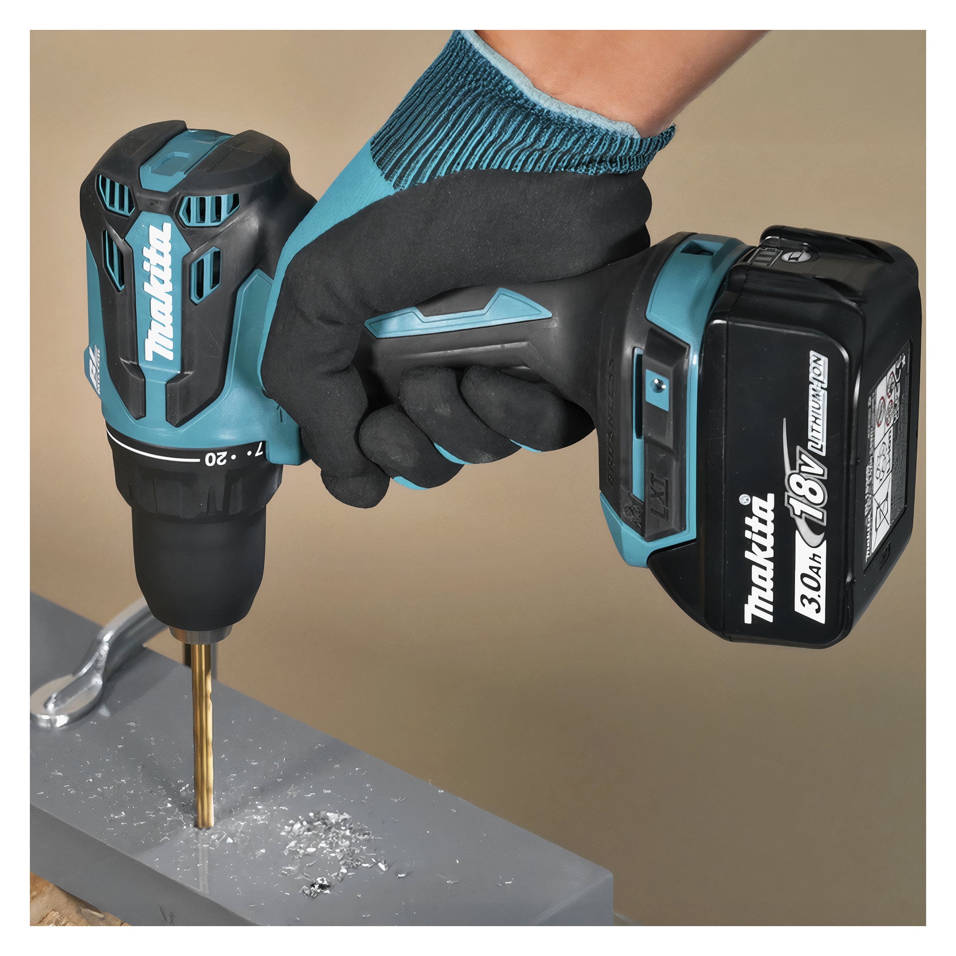 En hand med handske använder en sladdlös borr från Makita med en guldborr för att borra i grå metall och sprida vita spån runt hålet.