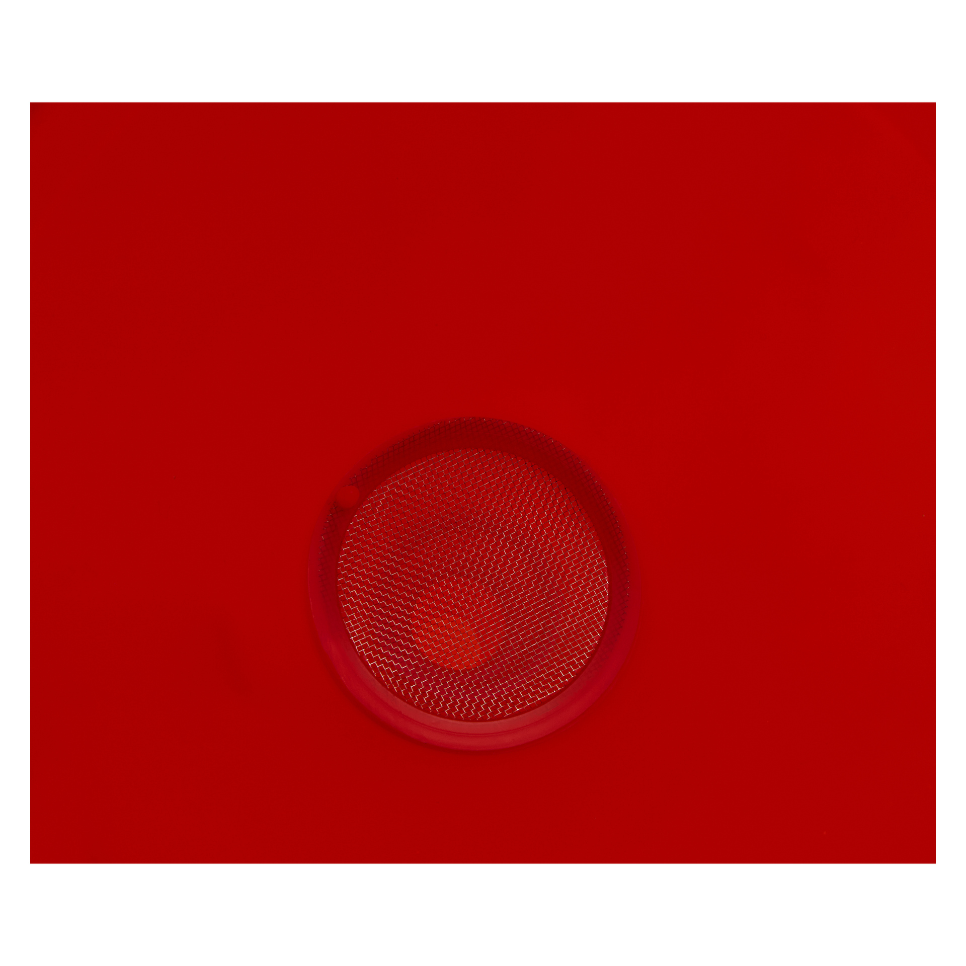 Närbild på en röd cirkulär reflektor med en texturerad yta, centrerad på en matchande röd bakgrund, möjligen från ett fordon.