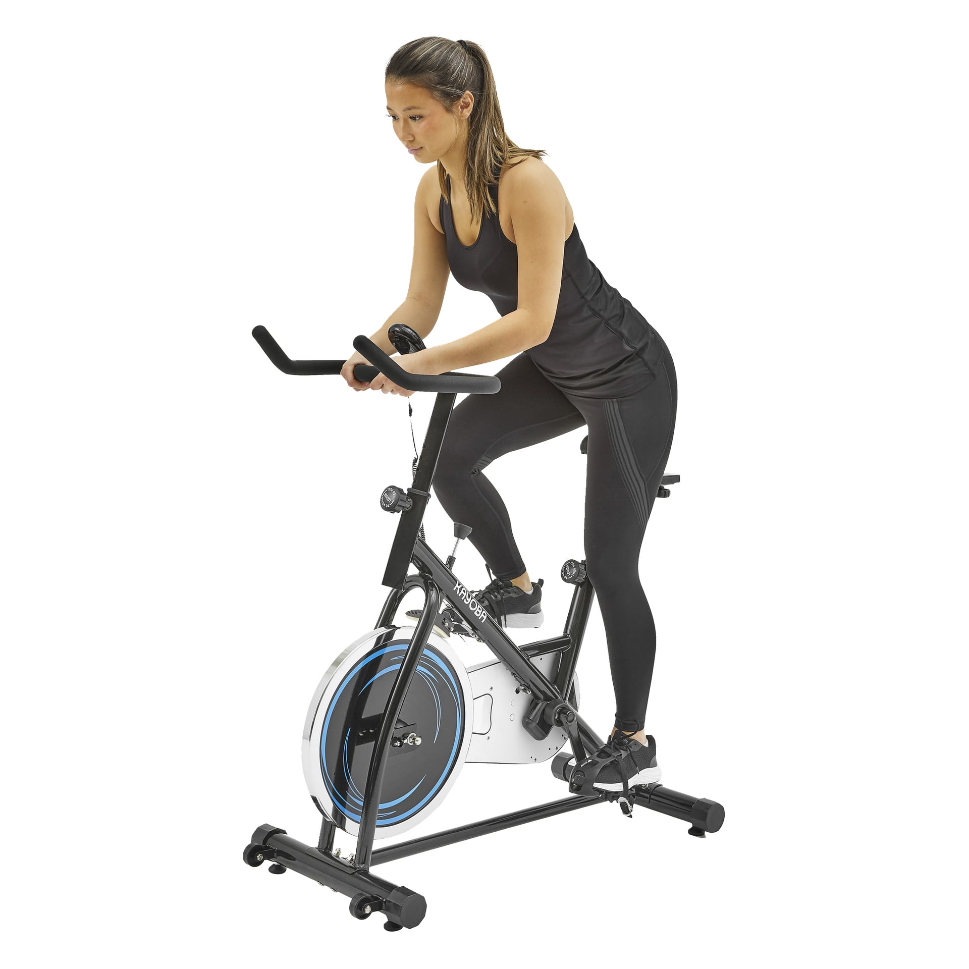 En person i svart ärmlös topp och leggings trampar på en svart motionscykel med blått och vitt svänghjul som håller styret.