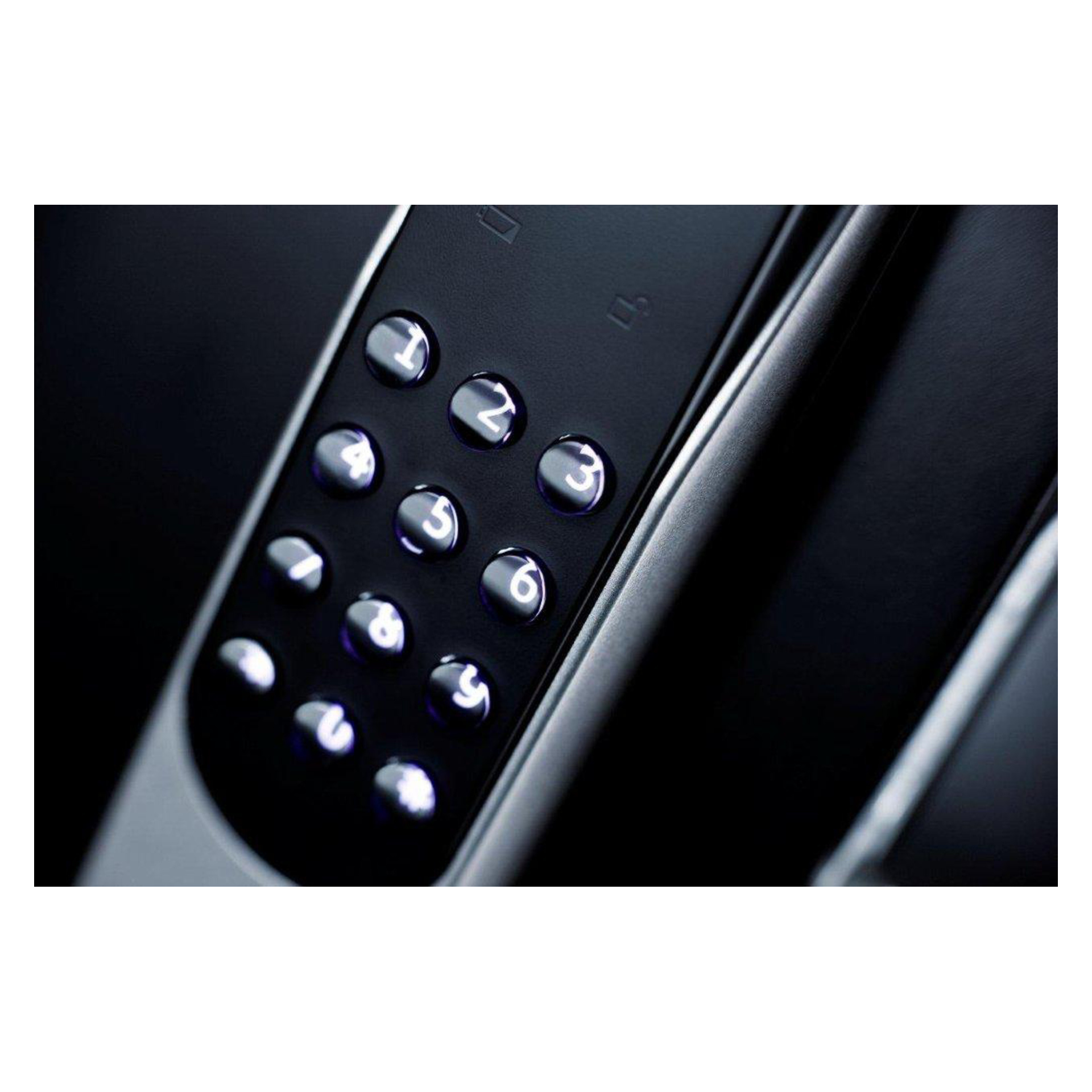 Nærbilde av et elegant numerisk tastatur med hvite bakgrunnsbelyste taster som viser tallene 1–9, sannsynligvis fra en elektronisk dørlås.