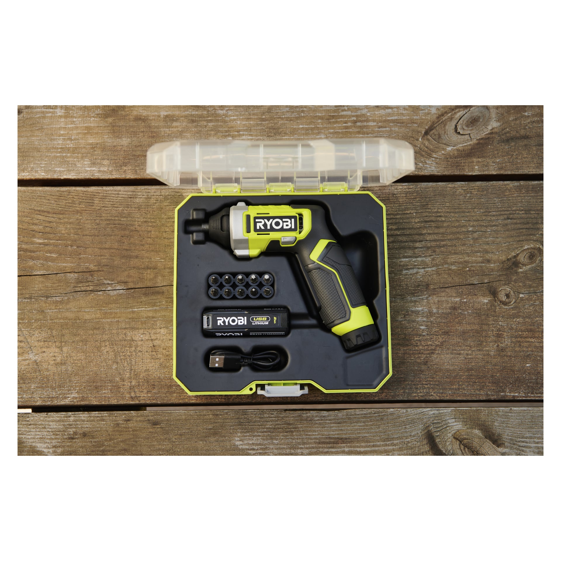 Ryobi trådløst skrutrekkersett vises i et åpent etui på tre, med verktøy, bits, lader og USB-kabel i støpte spor.