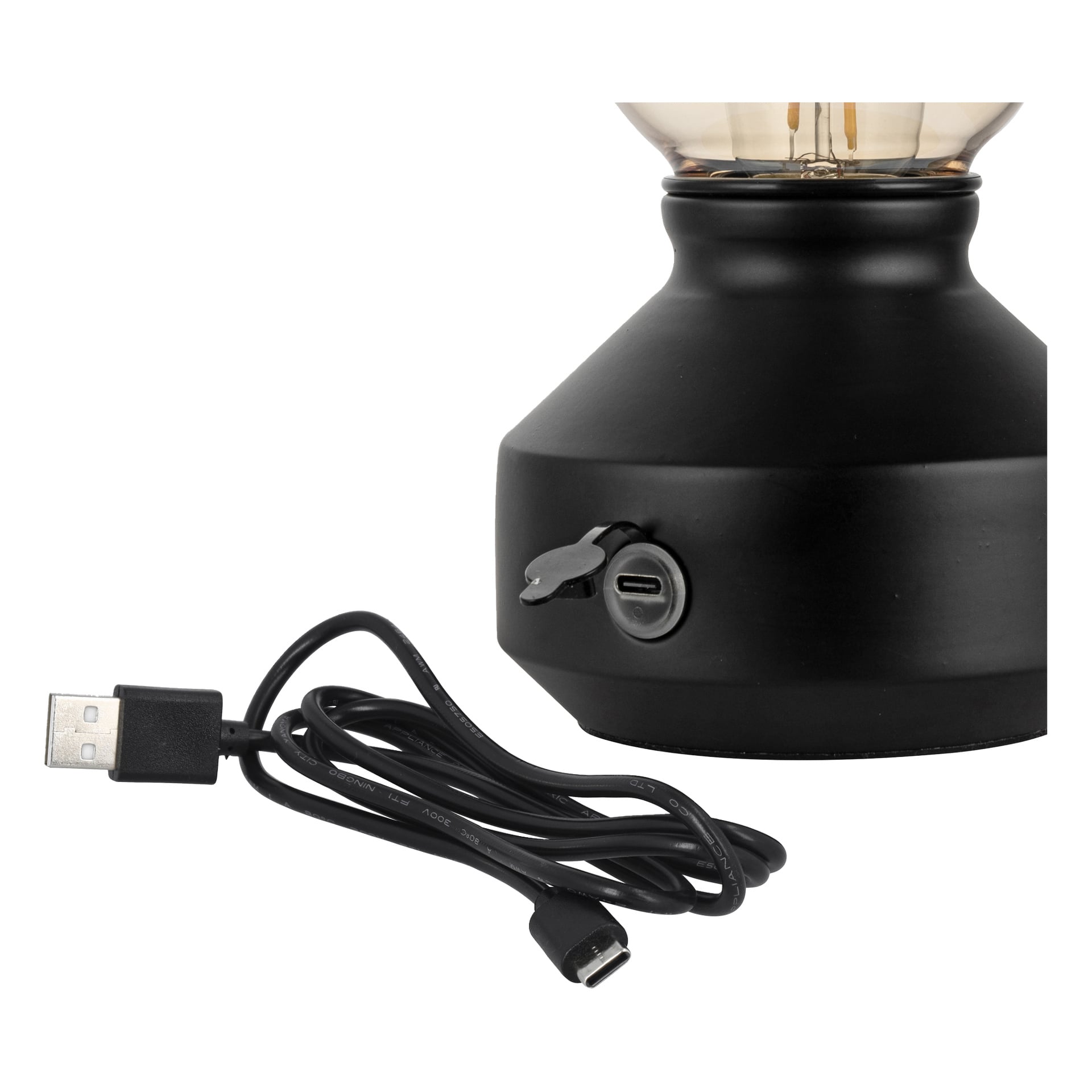 Lähikuva mustasta lampun jalustasta, jossa on USB-C-latausportti kumisuojuksella; USB-A–USB-C-kaapeli on edessä.