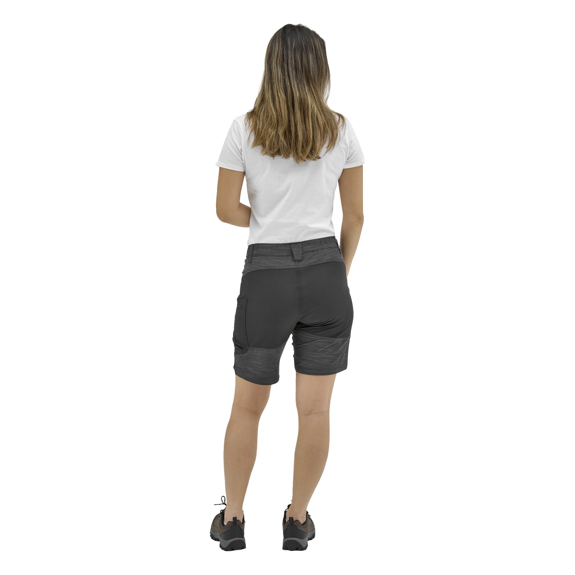 En person med långt brunt hår, klädd i en vit kortärmad skjorta, mörkgrå shorts och svarta sneakers, står vänd bort.