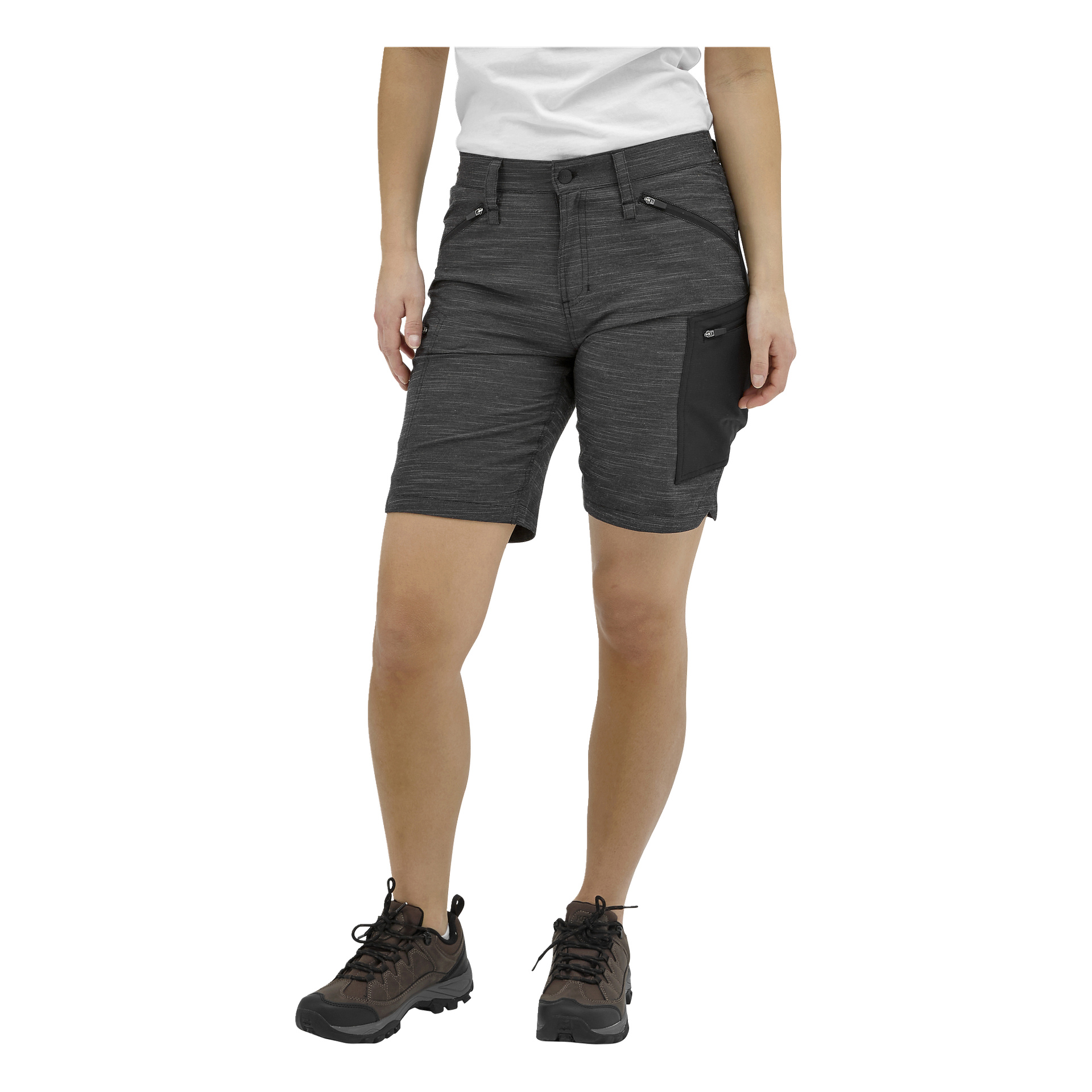 En person i vit skjorta, mörkgrå knälånga shorts med svart dragkedjasficka på höger lår och mörka vandringsskor.