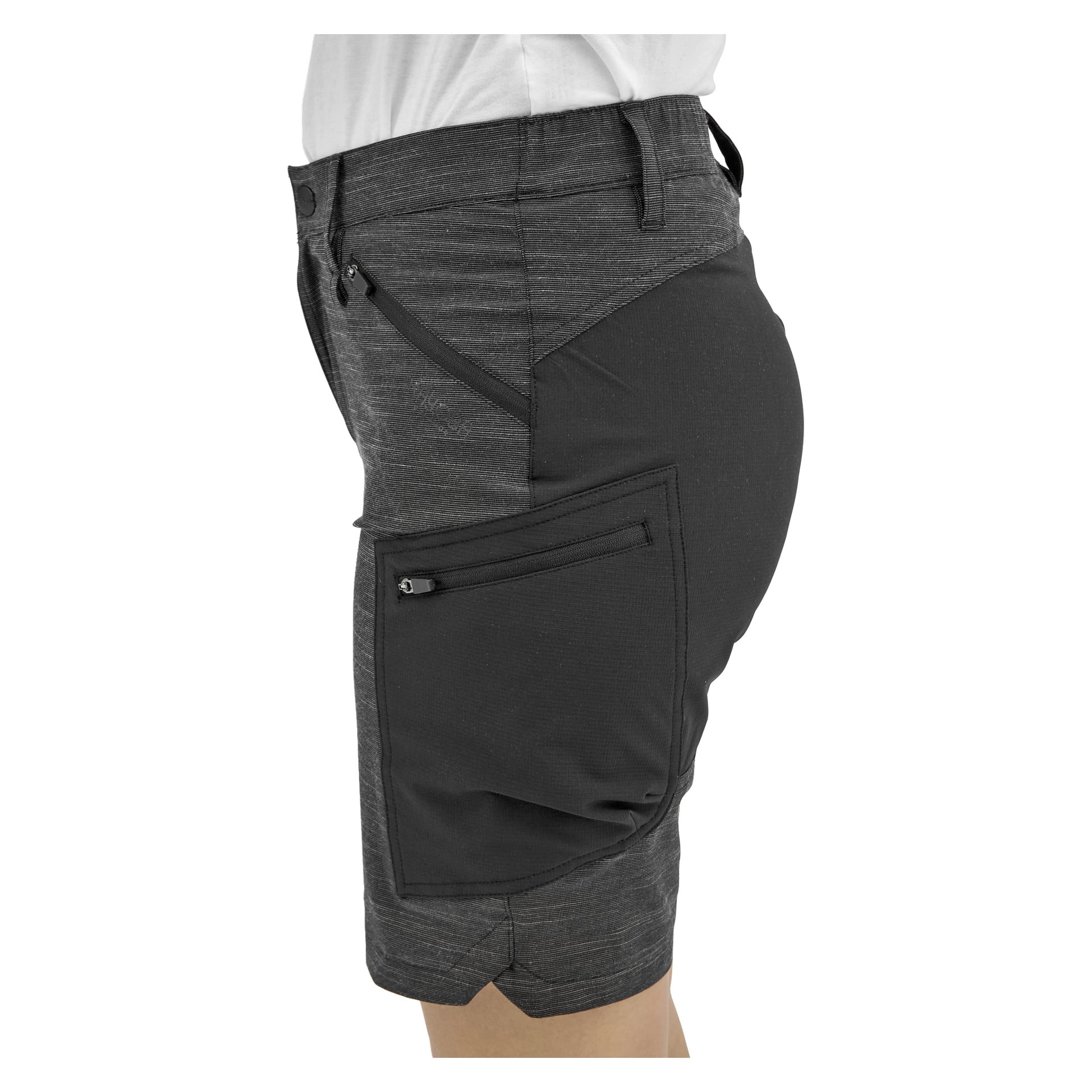 En person i mörkgrå shorts, med en stor sidoficka med dragkedja och en mindre precis ovanför, sedd från sidan.