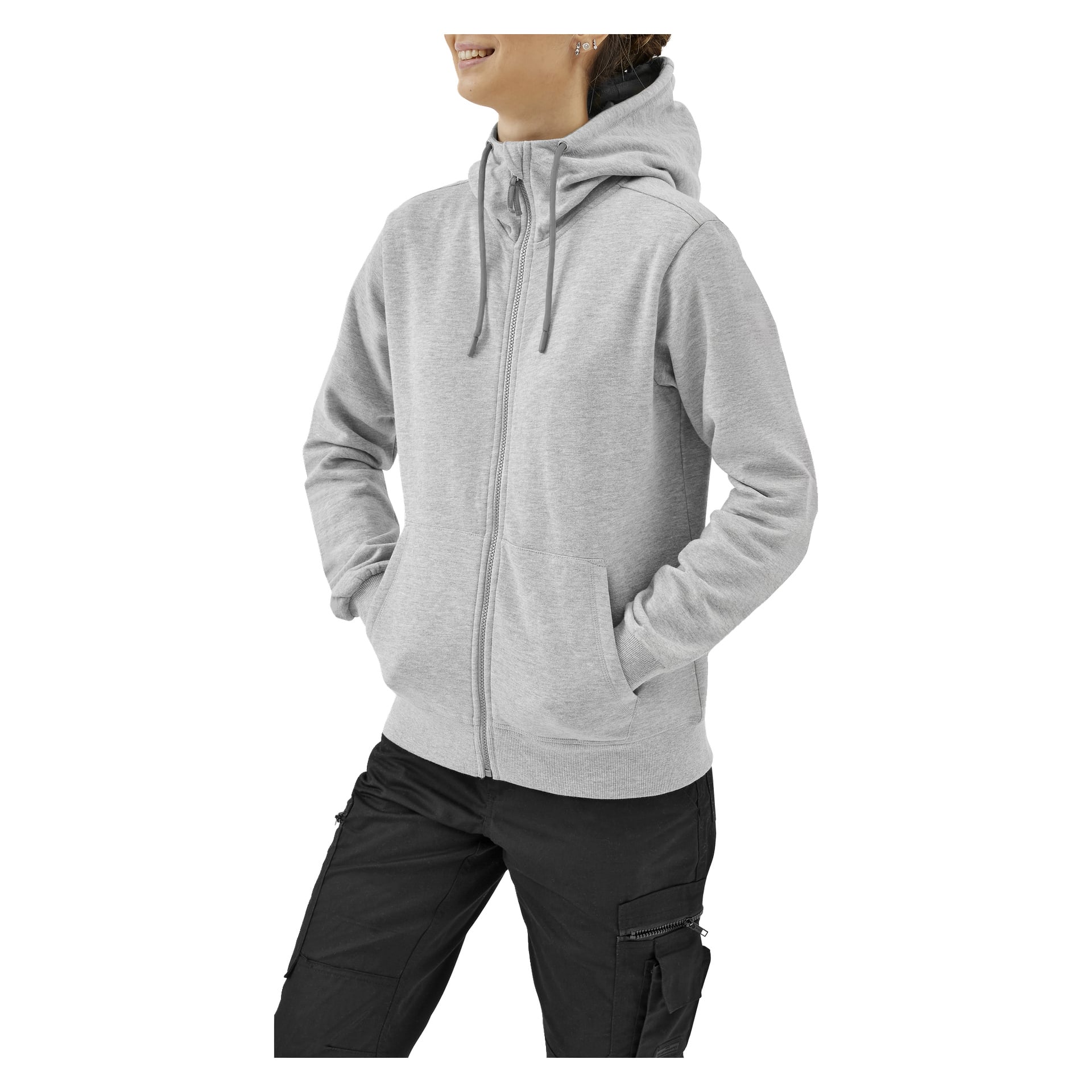 En person i en ljusgrå hoodie med dragkedja och huva med dragsko och svarta cargobyxor står med händerna i fickorna.
