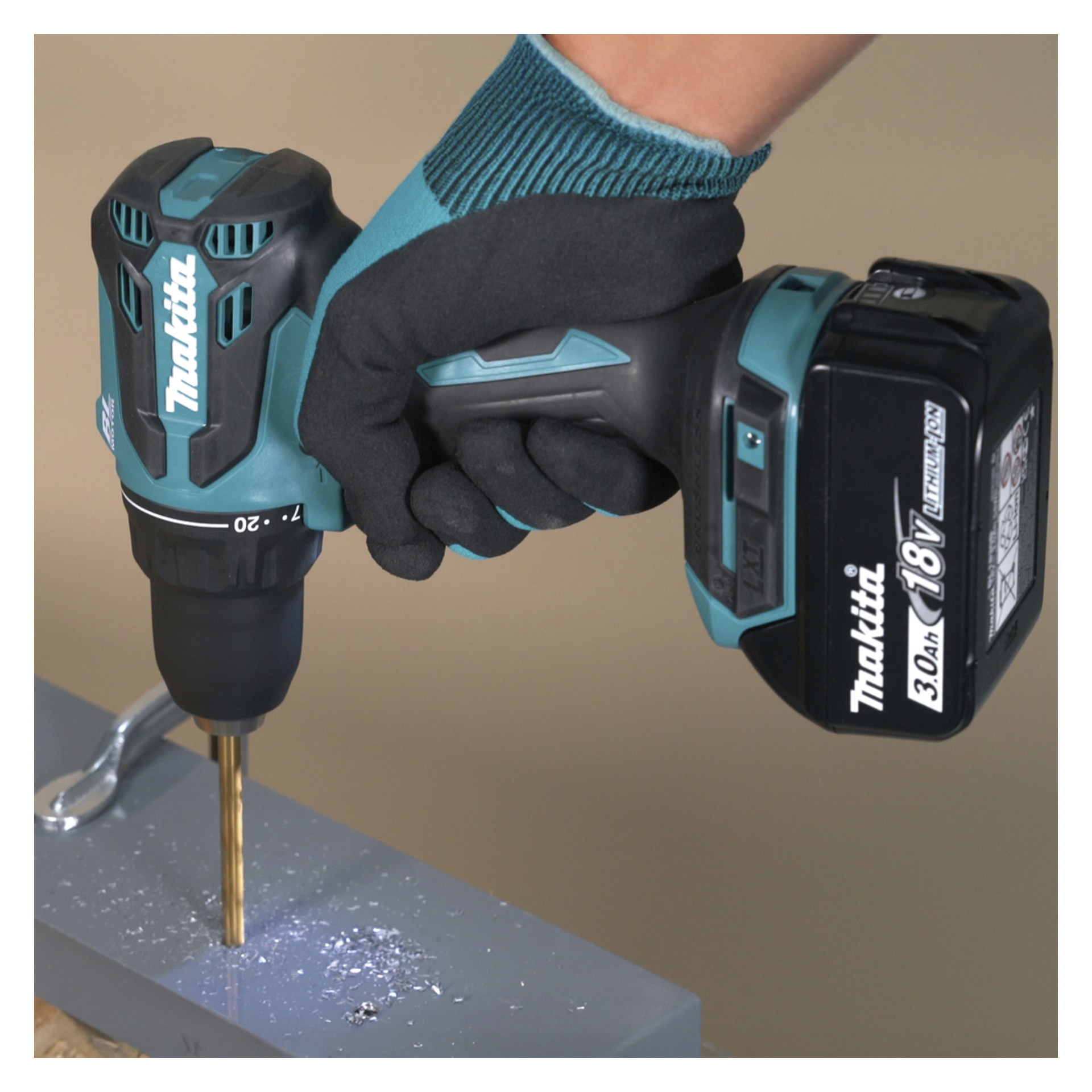 En handskbeklädd hand manövrerar en Makita sladdlös borr med en metallborr, vilket skapar spån när den borrar i en platt metallplåt.