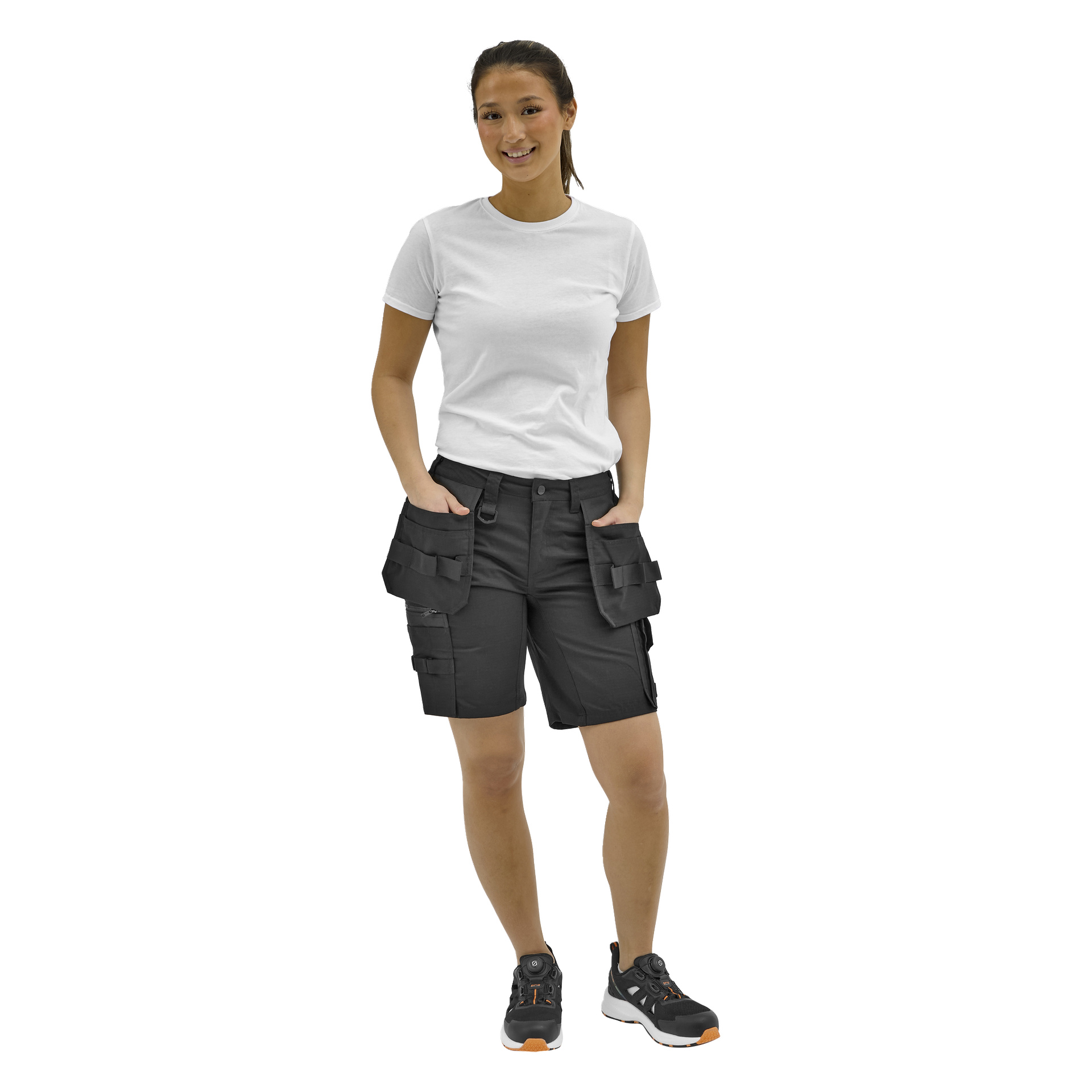 Personen vänder sig framåt i en enkel vit t-shirt, svarta cargoshorts med många fickor och svarta sneakers med vita sulor och orange detaljer.