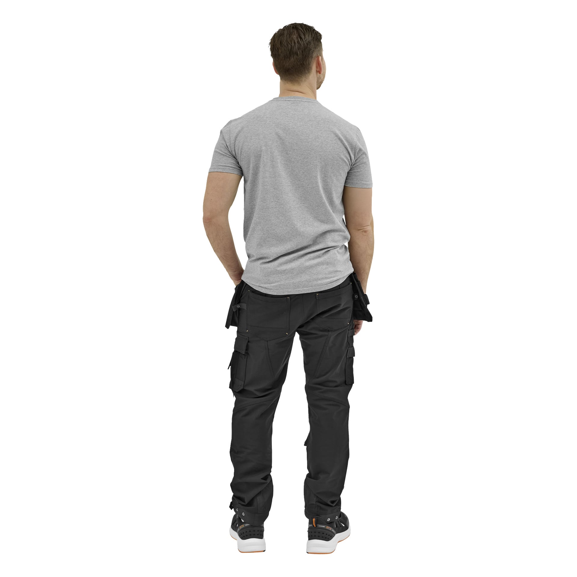 En man vänder sig bort, klädd i en grå kortärmad t-shirt, svarta cargobyxor med fickor och svarta sneakers. Armarna vilar vid sidorna.