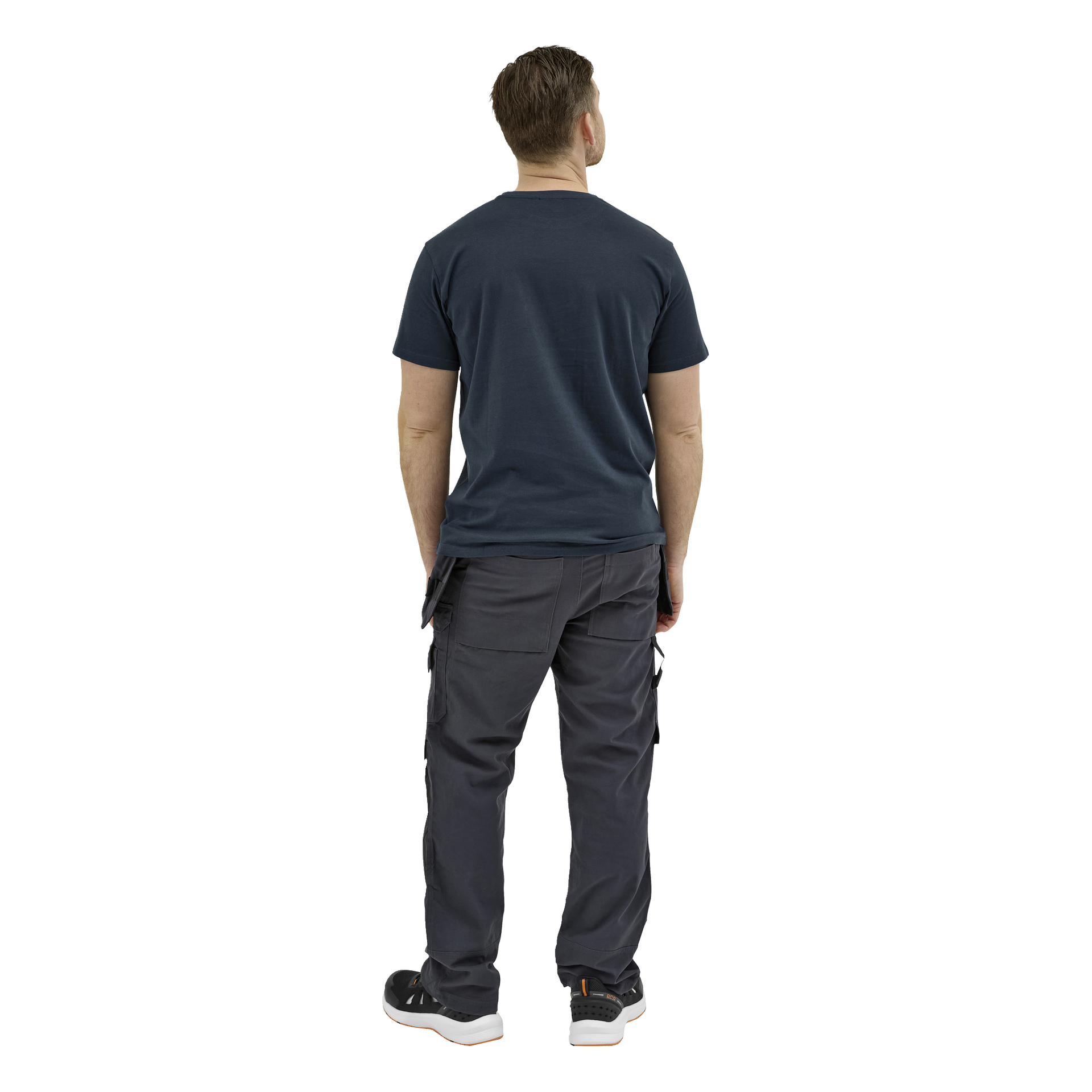 En mann vender ryggen til kameraet i en mørk kortermet t-skjorte, cargobukser og svarte joggesko med hvite såler, armene langs sidene.