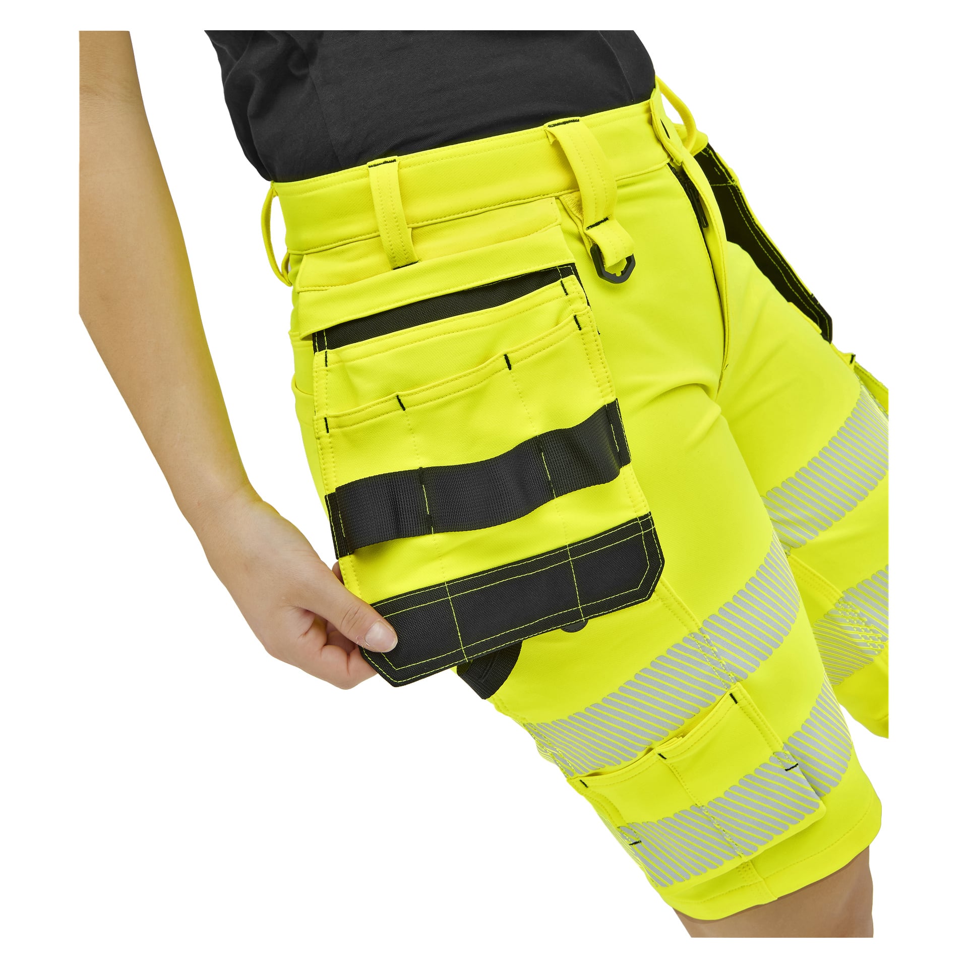Någon i livfulla gula verktygsshorts med reflekterande ränder och svartkantade fickor, som drar i en rymlig sidoficka.