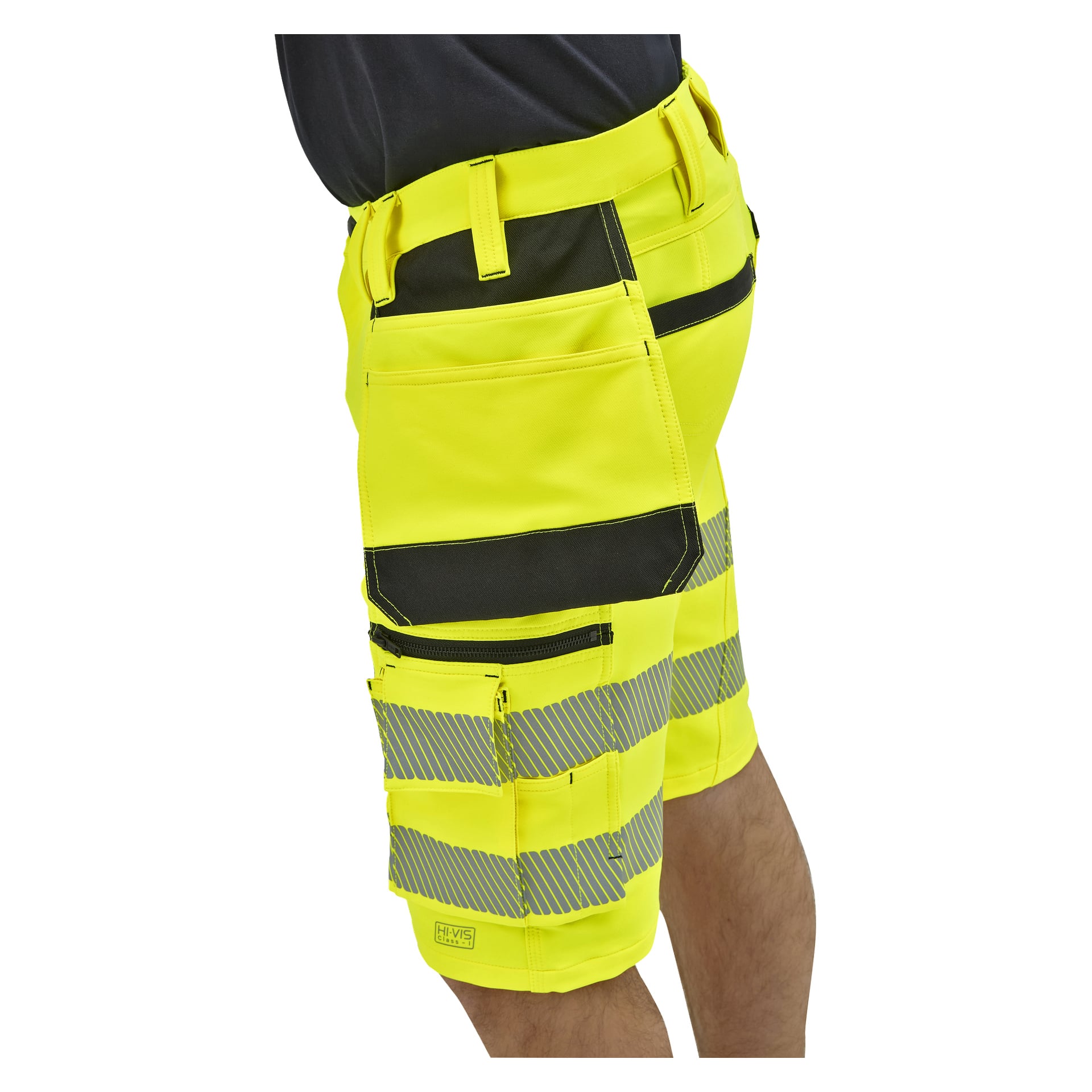 En person bär gula arbetsshorts med synliga silverfärgade reflekterande ränder, svarta fickdetaljer, verktygsögglor och många fickor.