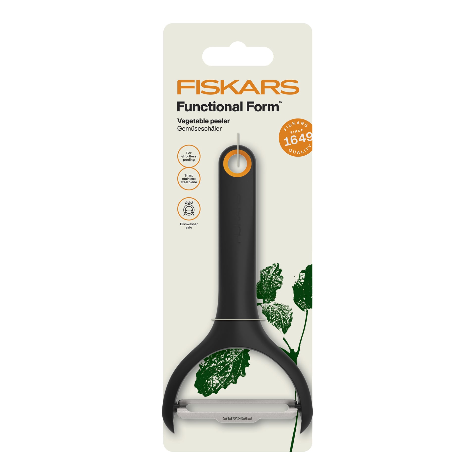 En Fiskars Functional Form grönsaksskalare i svart förpackning med metallblad och orange detaljer, märkt som diskmaskinssäker.