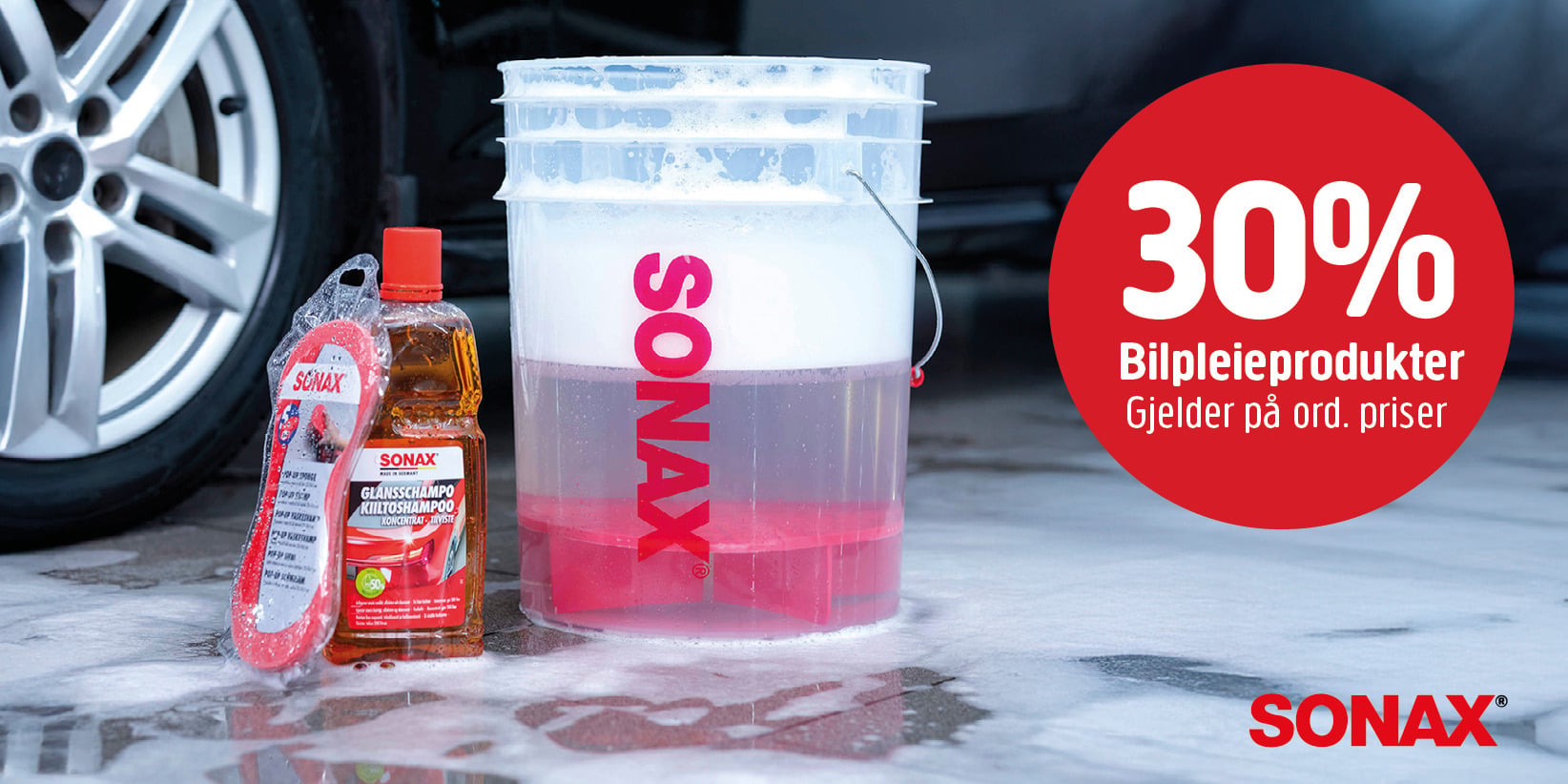 Ved siden av en bil står en gjennomsiktig bøtte med skum, SONAX Blodlappsjampo og en svamp. En rød sirkel annonserer 30 % rabatt på bilpleieprodukter.