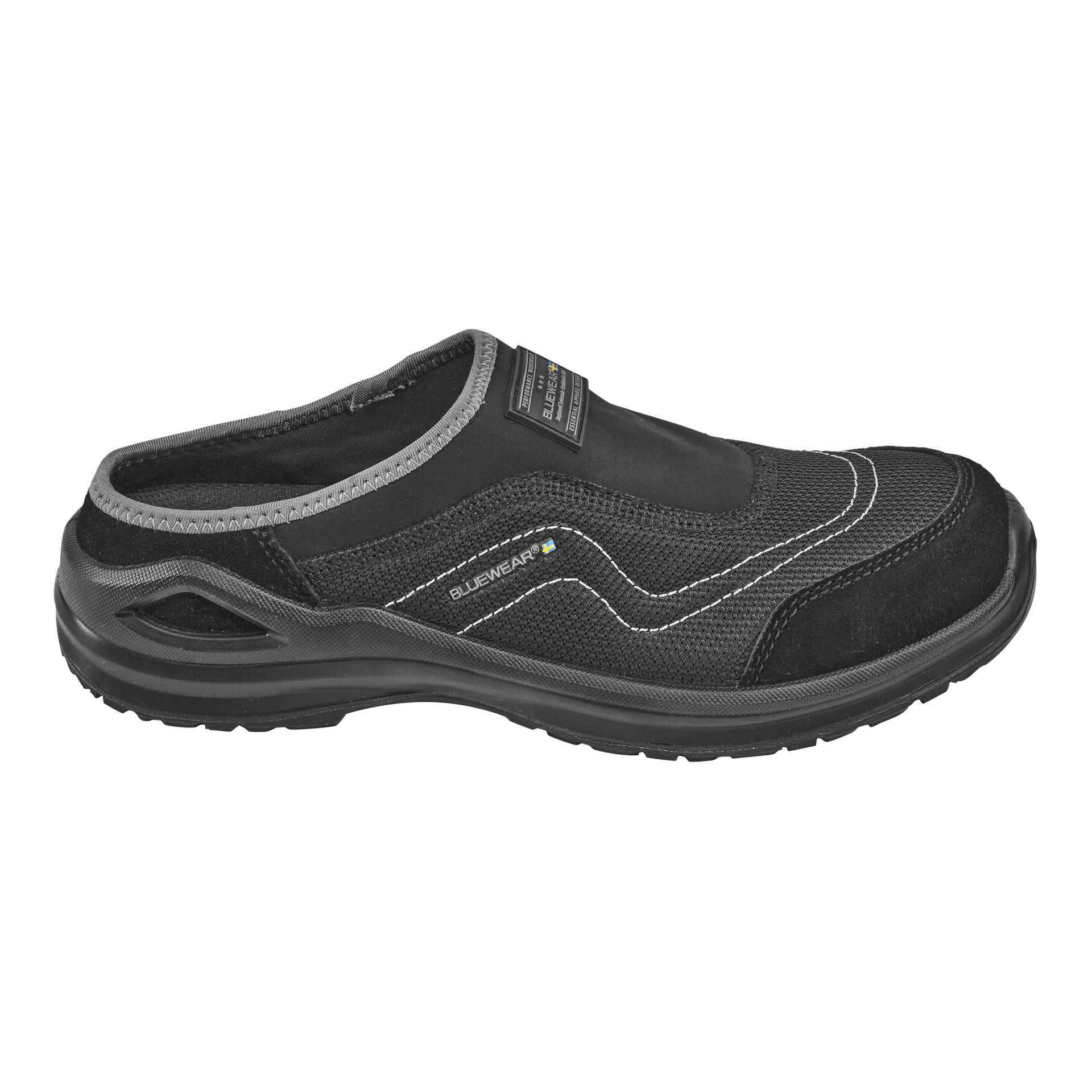 Svarte slip-on Bluewear sikkerhetssko Tampa med teksturert såle, overdel i mesh-stoff, semskede detaljer og hvite sømmer. Siden viser en Bluewear-logo. Designet med en lavt kuttet lukket hæl for enkel bruk og avtakning.