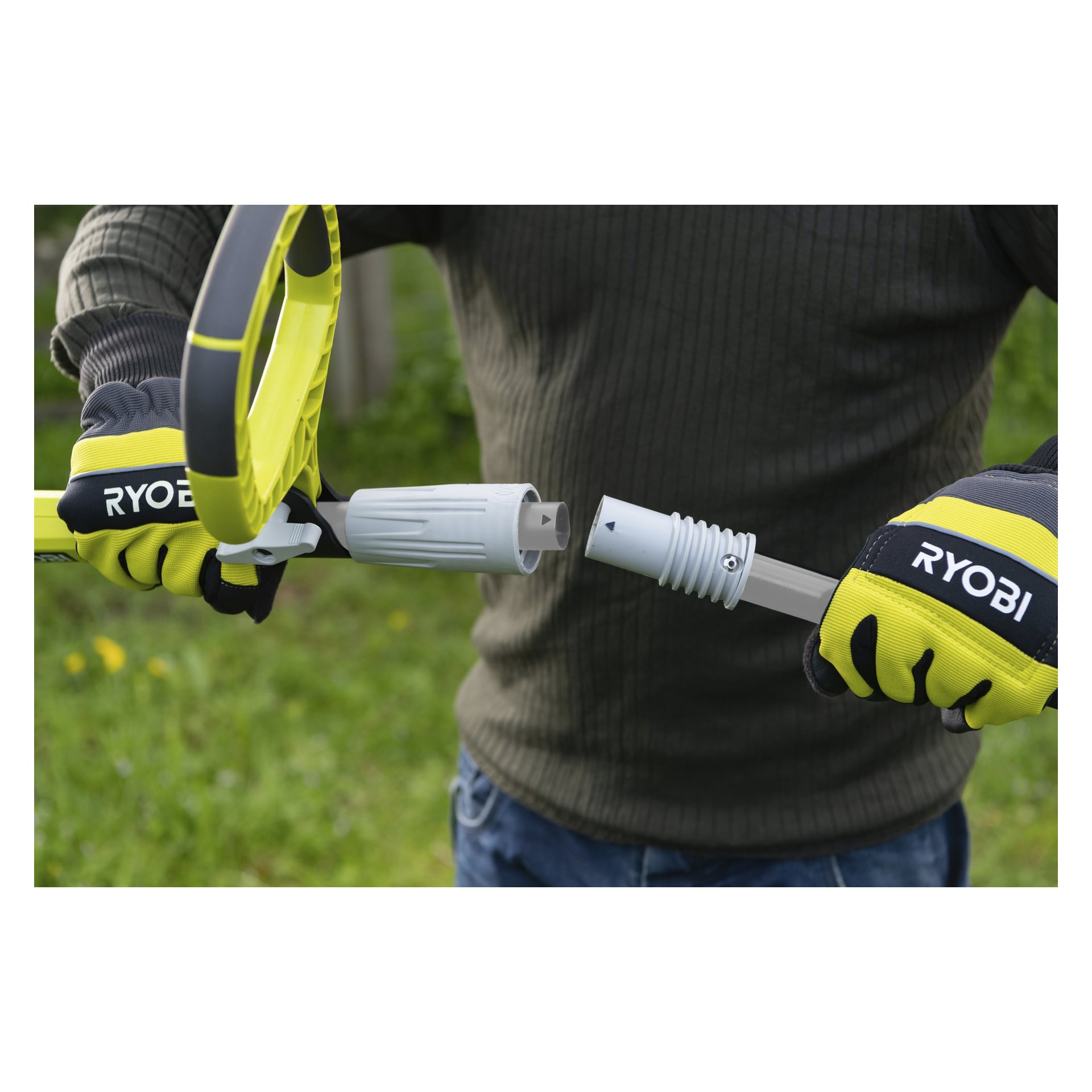 Osoba w rękawiczkach trzyma dwa odłączone segmenty wału przedłużającego piłę do przycinania Ryobi Max Power Battery RY36PP25A-0, ustawiając strzałki kierunkowe na mechanizmie sprzęgającym mechanizm.