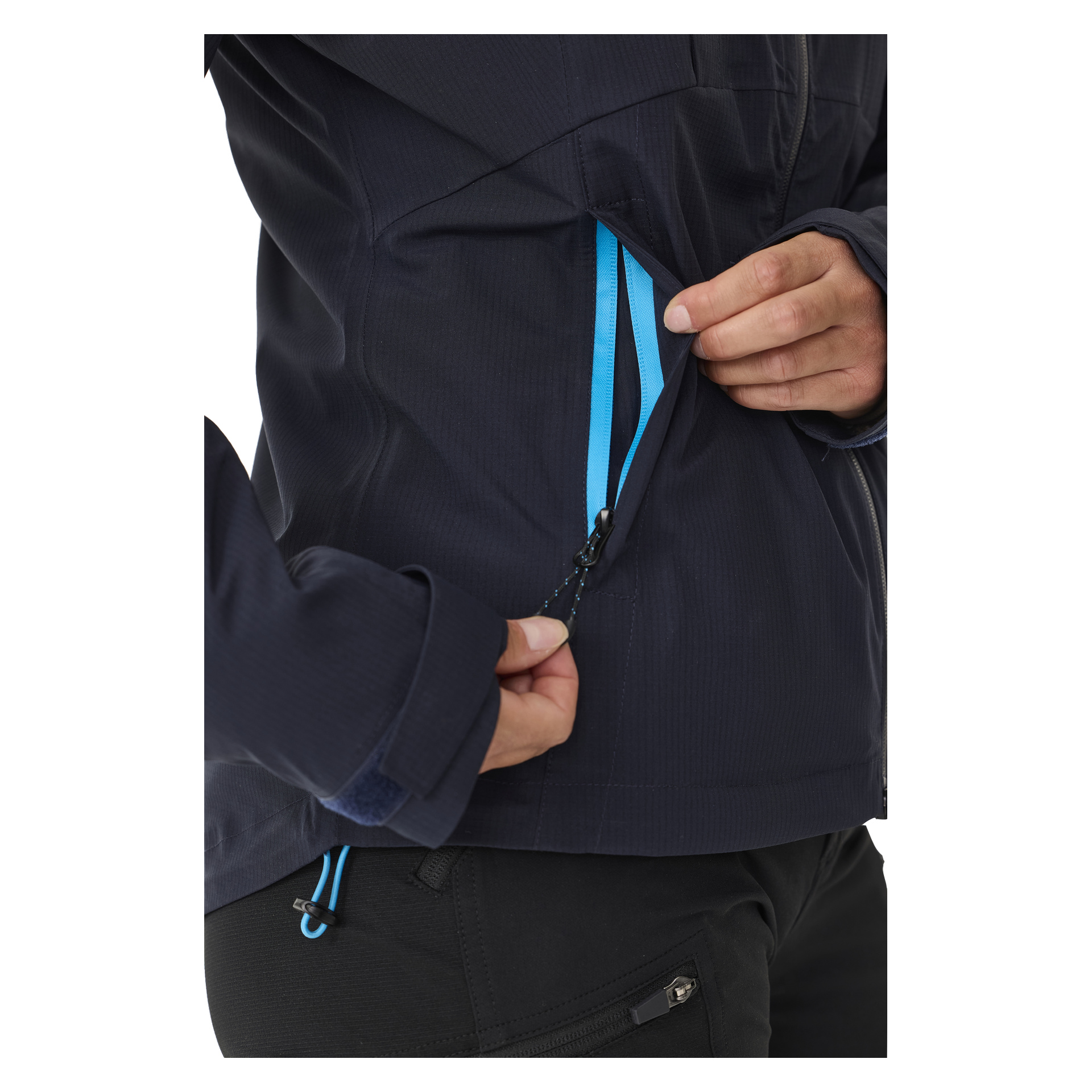 Eine Nahaufnahme zeigt die Hände einer Person, wie sie den blauen Reißverschluss an der Brusttasche der Kayoba Outdoor Women's Shell Jacket Sarek öffnen, wobei der Fokus auf detaillierte Jackenmerkmale gelegt wird und nur teilweise der Körper sichtbar wird.
