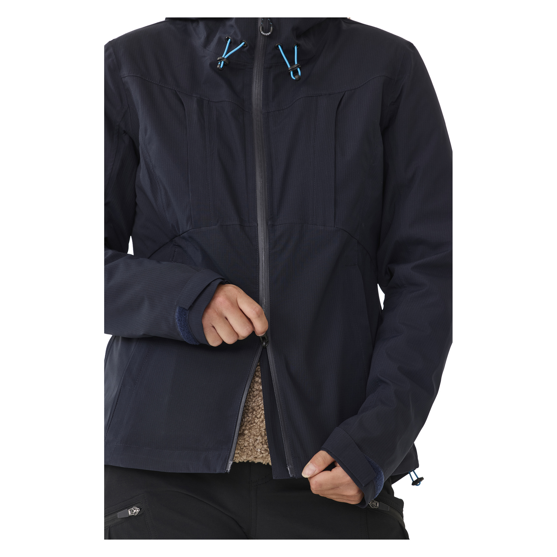 Man zieht den dunkelblauen Kayoba Outdoor Women's Shell Jacket Sarek zu, der blaue Kordeln hat und darunter eine beige Fleeceschicht zeigt. Nur der Oberkörper und die Hände sind sichtbar.