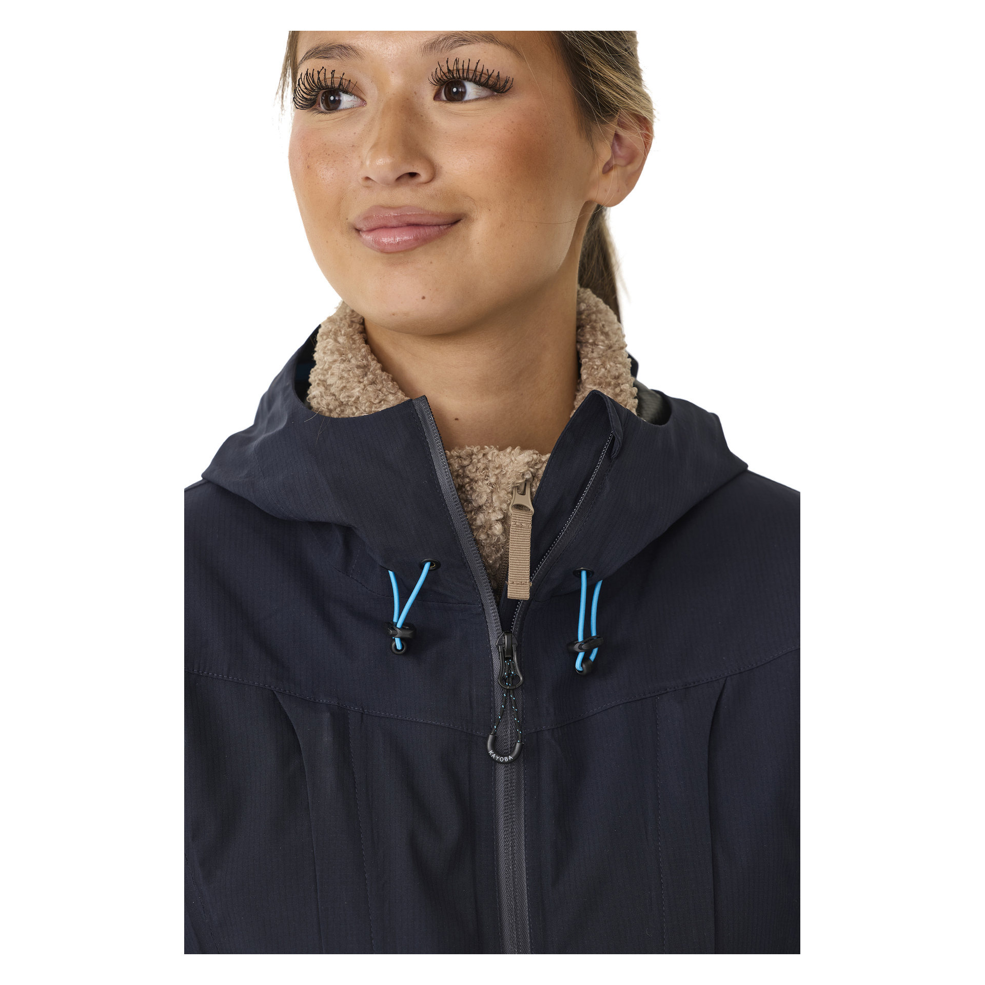 Eine Frau schaut zur Seite, während sie die Kayoba Outdoor Women's Shell-Jacke Sarek trägt, die blaue Kordeln und einen beigefarbenen Fleecekragen hat.