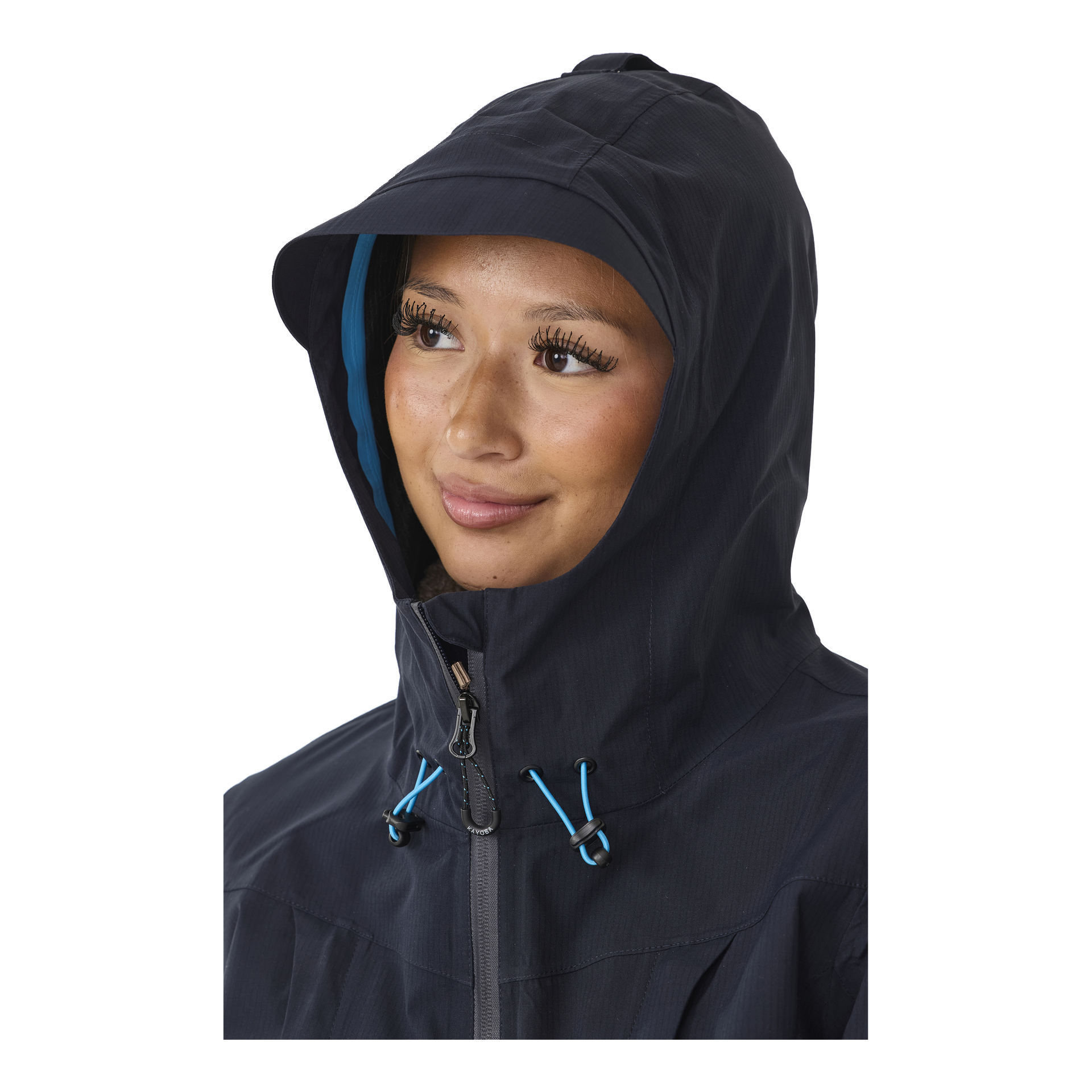 Eine Frau in einer dunklen Kayoba Outdoor Damen-Shelljacke Sarek mit blauen Kordeln und Reißverschlussständern, leicht nach rechts gedreht, mit einem dezenten Lächeln.