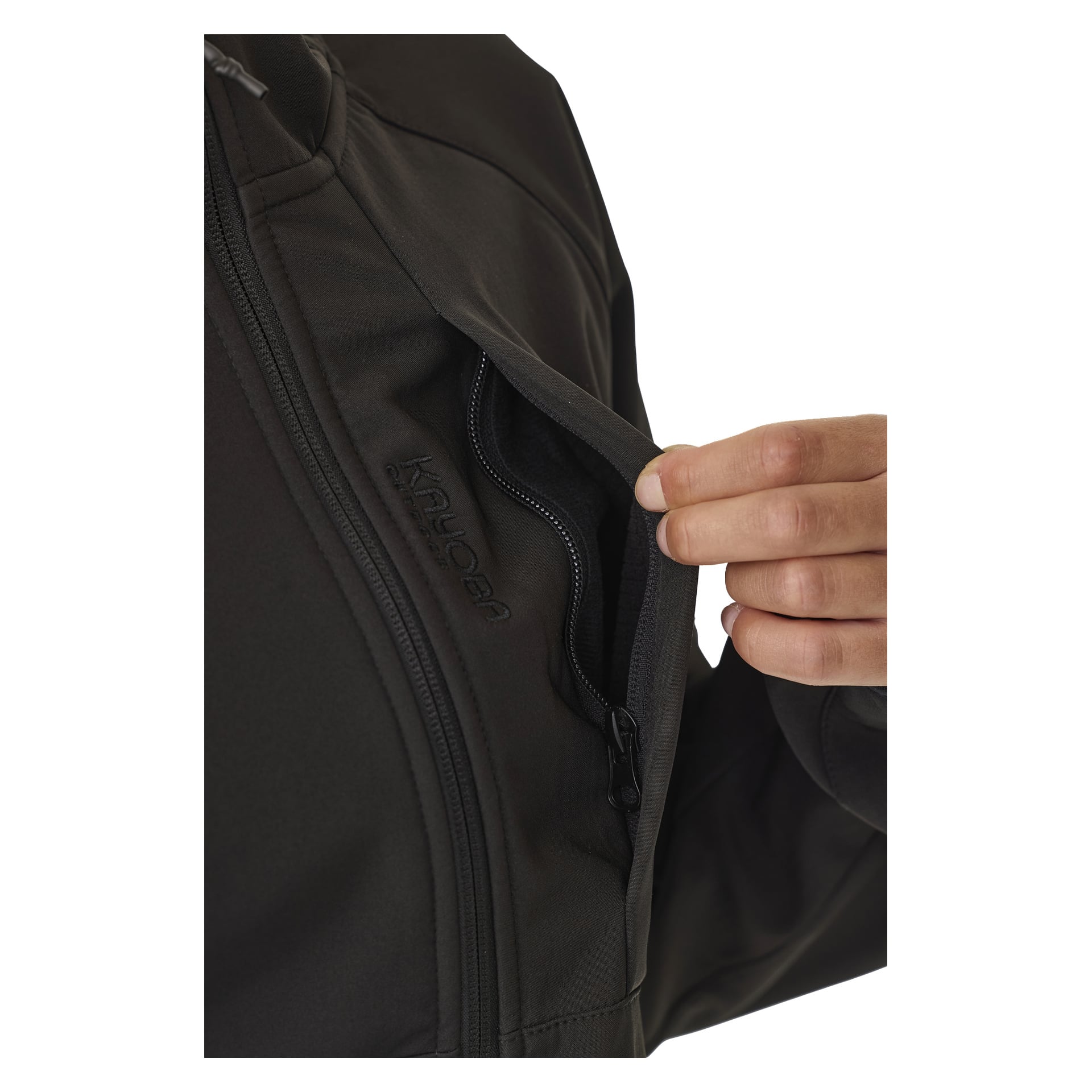 Eine Hand öffnet die Brusttasche einer schwarzen Jacke und zeigt das bestickte "Kayoba Outdoor"-Logo auf der Tasche. Die Jacke wird als die mit Fleece gefütterte Damen-Softshell-Jacke Hede identifiziert.