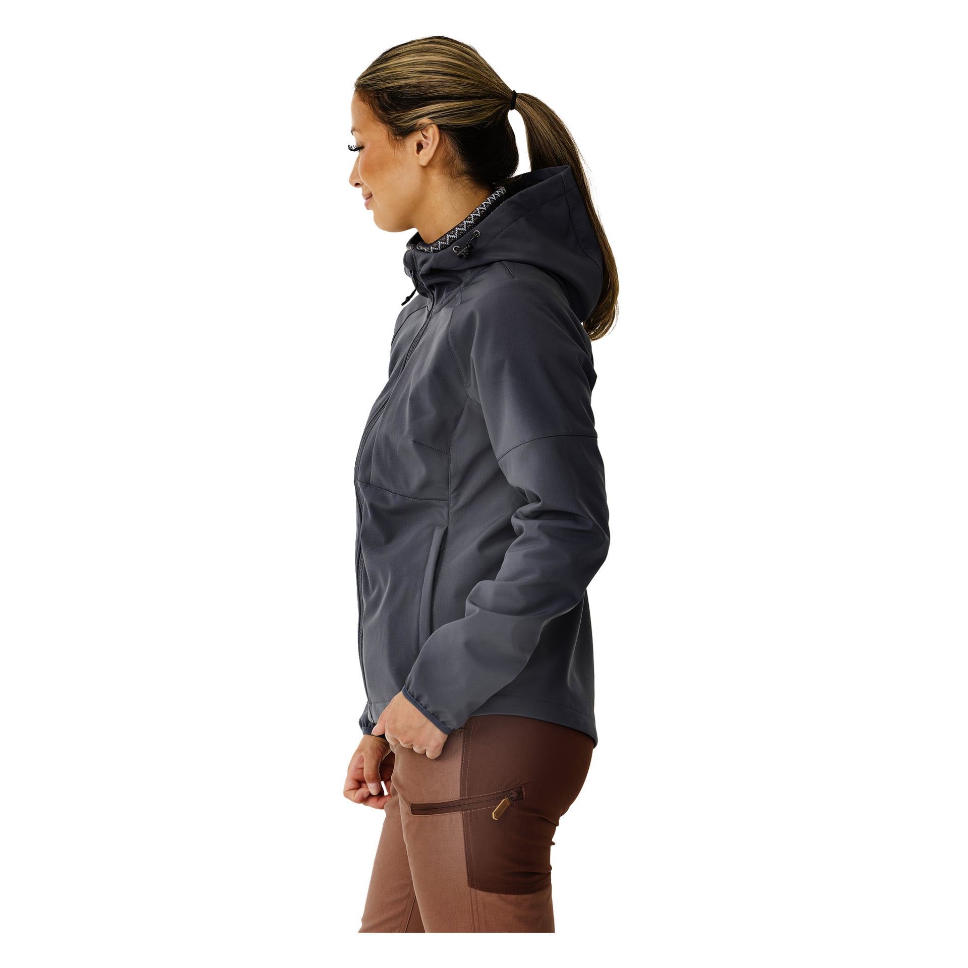 Eine Frau mit Pferdeschwanz steht im Profil nach links und trägt die Kayoba Outdoor Women's Softshell-Jacke Hede, die mit Fleece gefüttert ist, in dunkelgrauer und brauner Hose mit Reißverschlusstasche.