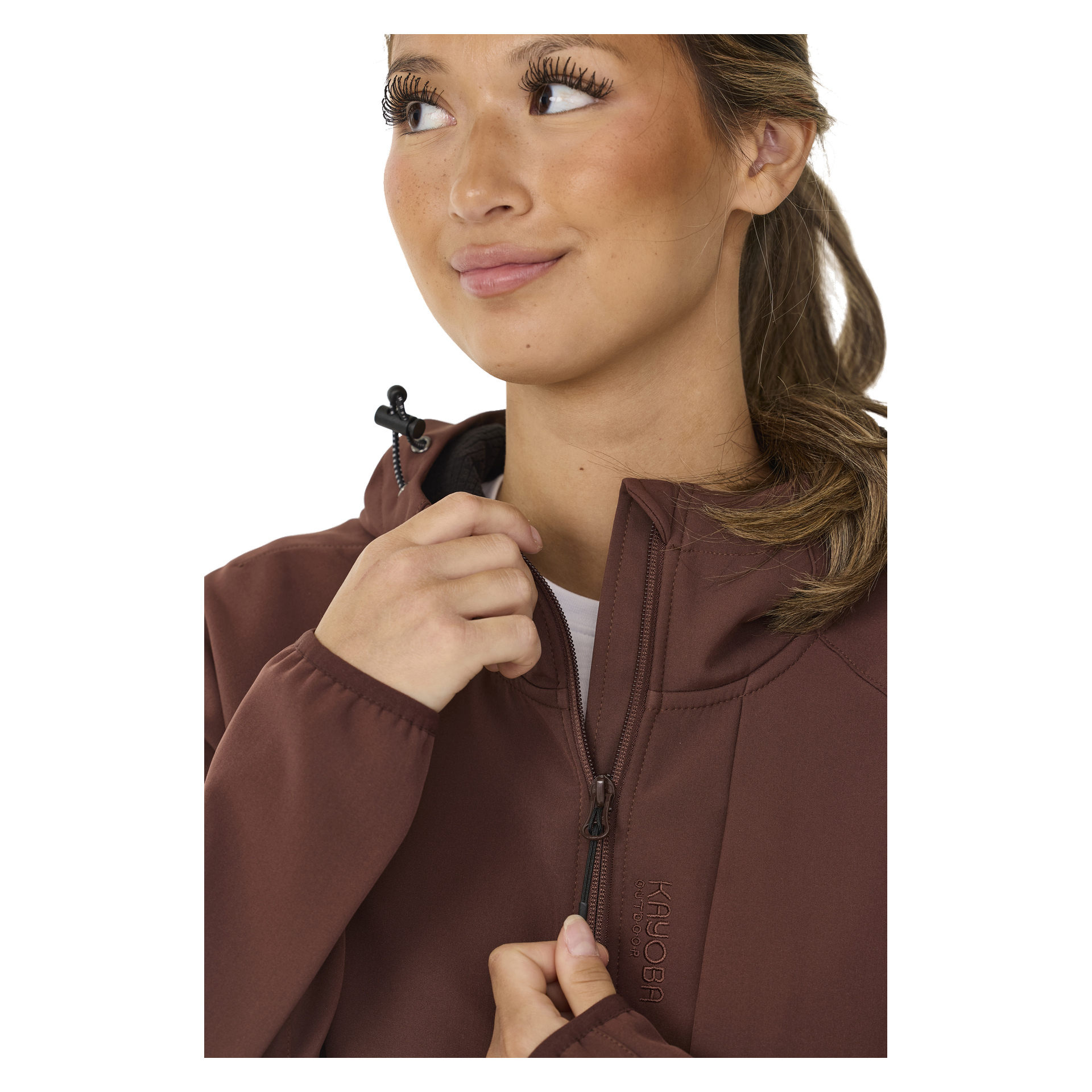 Eine Frau mit langen Wimpern und braunen Haaren richtet den Reißverschluss der mit Fleece gefütterten Softshell-Jacke Hede von Kayoba Outdoor Women.