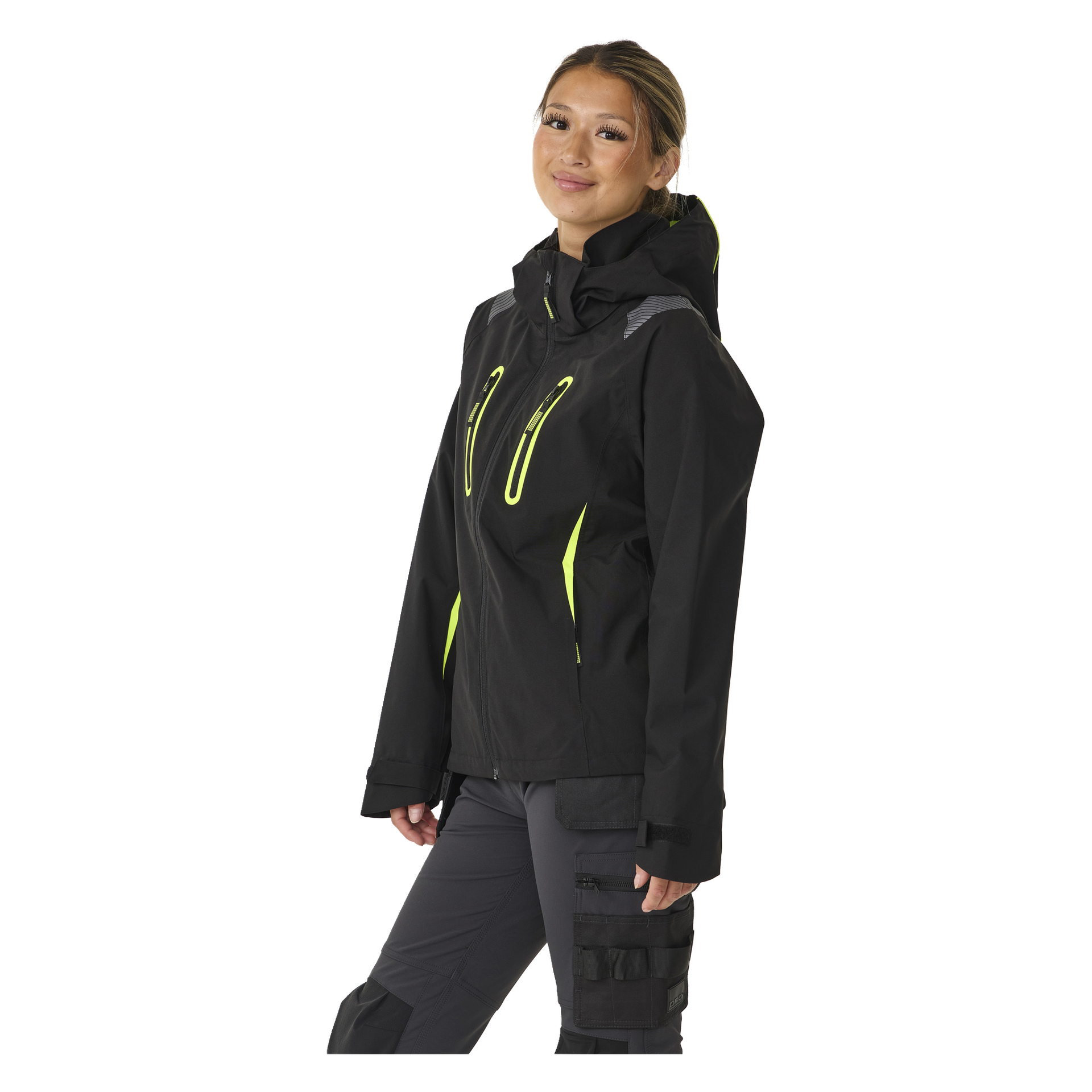 Eine Person präsentiert die Bluewear Women's Rebecca Stretch-Shelljacke, schwarz mit neongelben Akzenten und Kapuze. Die Jacke hat Reißverschlusstaschen an der Brust und an den Seiten. Das Haar der Person ist zurückgebunden, sie ist leicht zur Seite gedreht und ihr Gesichtsausdruck ist neutral.