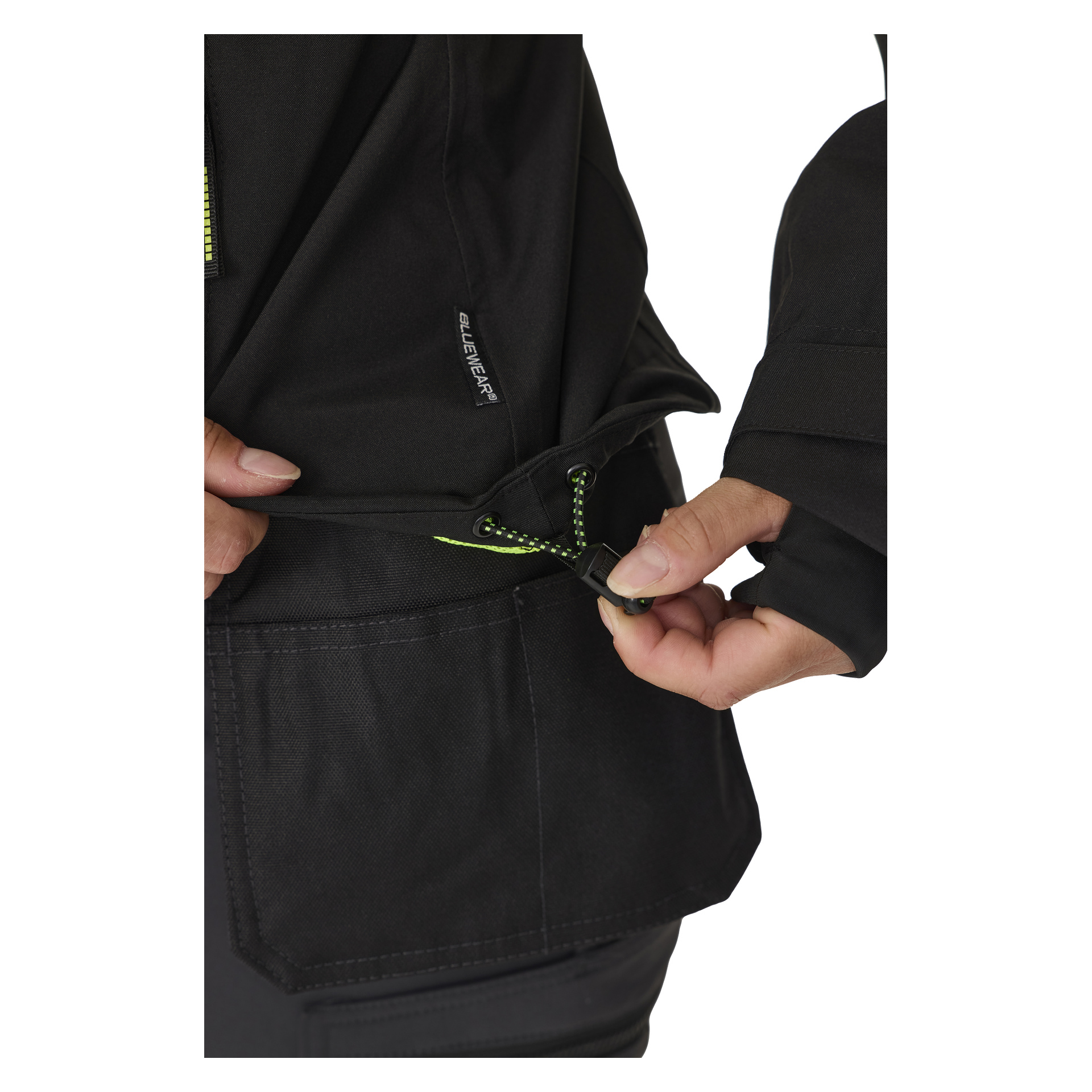 Die Taille der Bluewear Women's Stretch Shell Jacket Rebecca wird mit einem grün-schwarzen Kordel angepasst, der einen Kunststoff-Toggle hat. Das Bild ist eine Nahaufnahme, die die seitliche Reißverschlusstasche der Jacke hervorhebt.