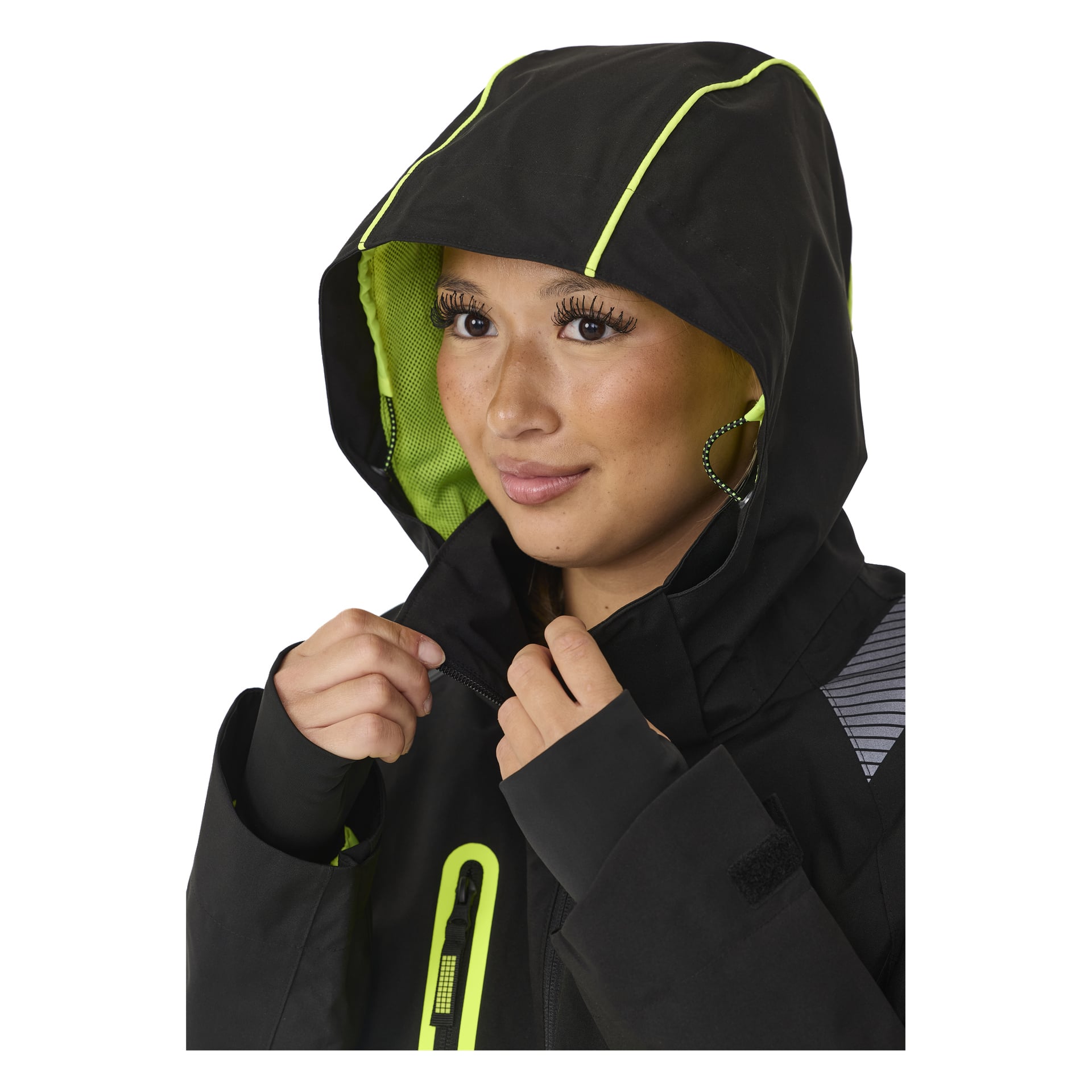 Henkilö mallintaa Bluewear Women's stretch shell -takkia Rebeccaa, jossa on musta väri, neonkeltaiset yksityiskohdat ja etuvetoketju. Huppu on ylhäällä, paljastaen verkkovuorun. Heillä on rengaskorvakoruja ja pitkät ripset.