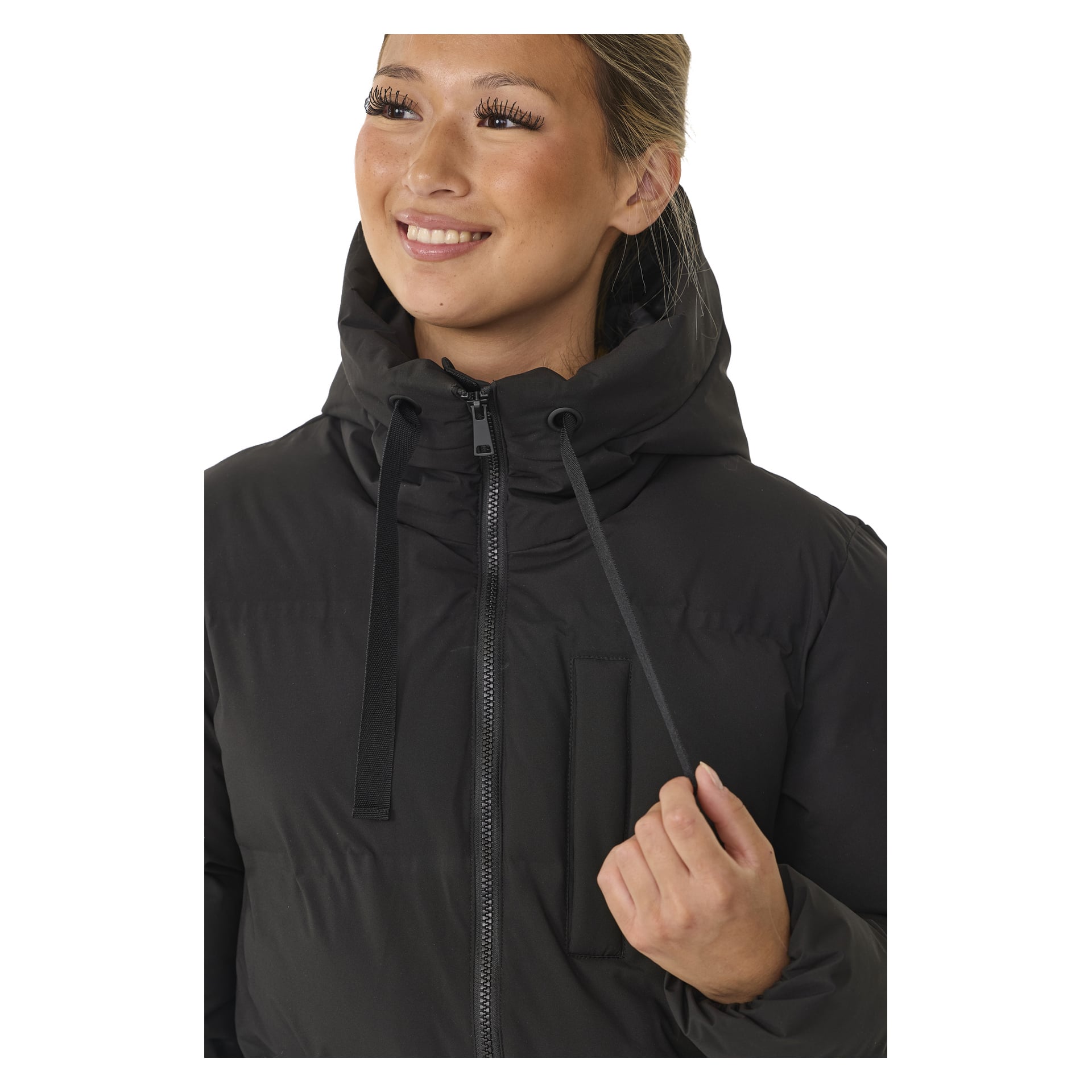 Henkilö mallintaa mustaa Kayoba Outdoor Women's talvitakkia Storlien, joka on esitetty rinnasta ylöspäin. He hymyilevät ja näyttävät hieman vasemmalta pitäen hupun nyöriä, takki täysin vetoketjussa.