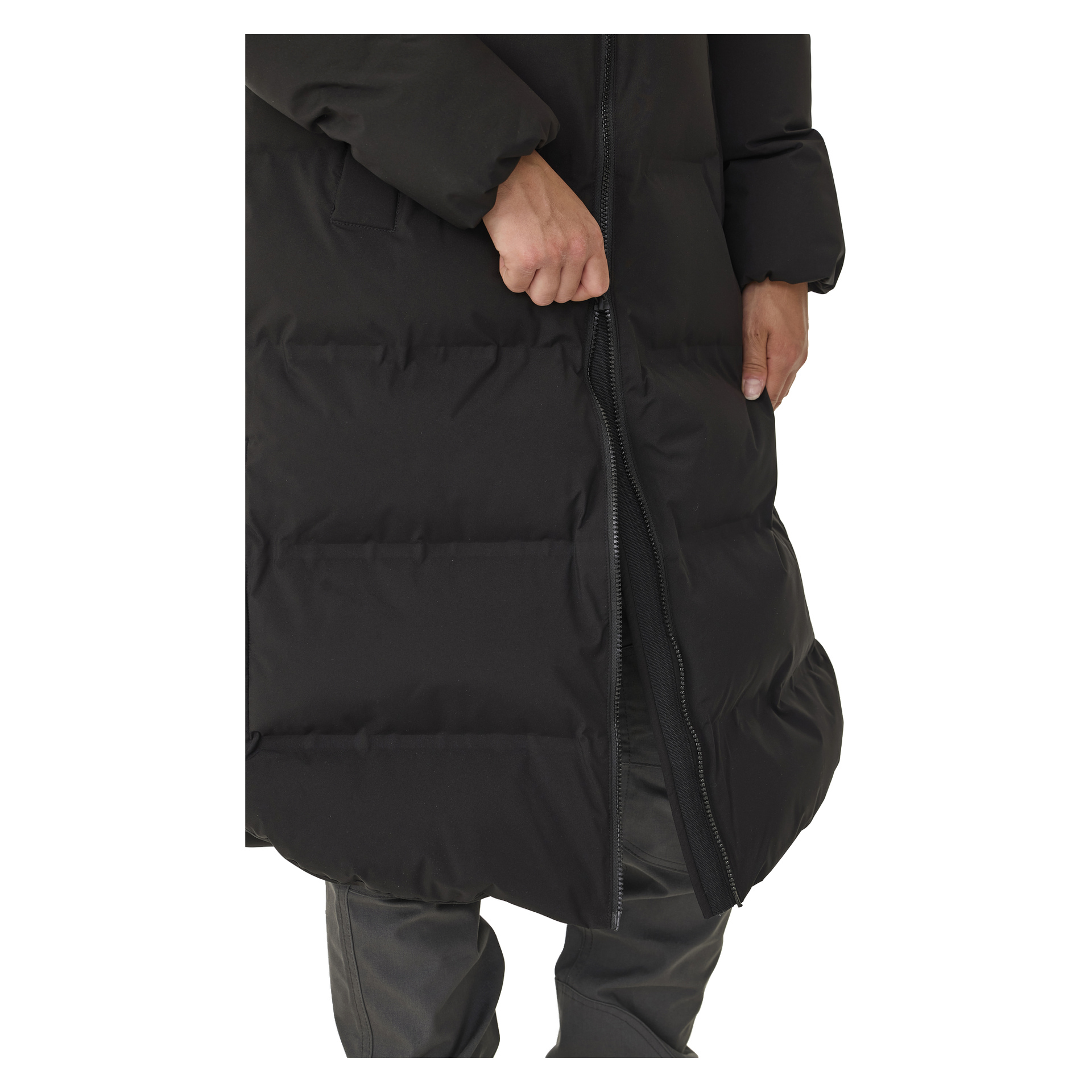Joku vetää vetoketjun kiinni mustaa Kayoba Outdoor Women's -talvitakkia nimeltä Storlien. Näkyvät vain kädet ja alavartalo, ja heillä on tummat housut.