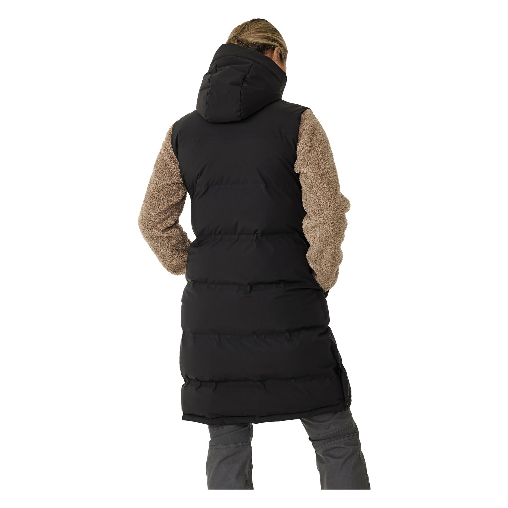 Nainen katsoo poispäin kamerasta, esittäen täyden takakuvan päästä polviin Kayoba Outdoor Padded Women's Gilet, Long Duved -puvussa—pitkässä mustassa huppullinen palloliivissä. Hän pukeutuu ruskean takin päälle, jossa on teksturoidut hihat ja harmaat housut, hiukset sidottuna taakse.
