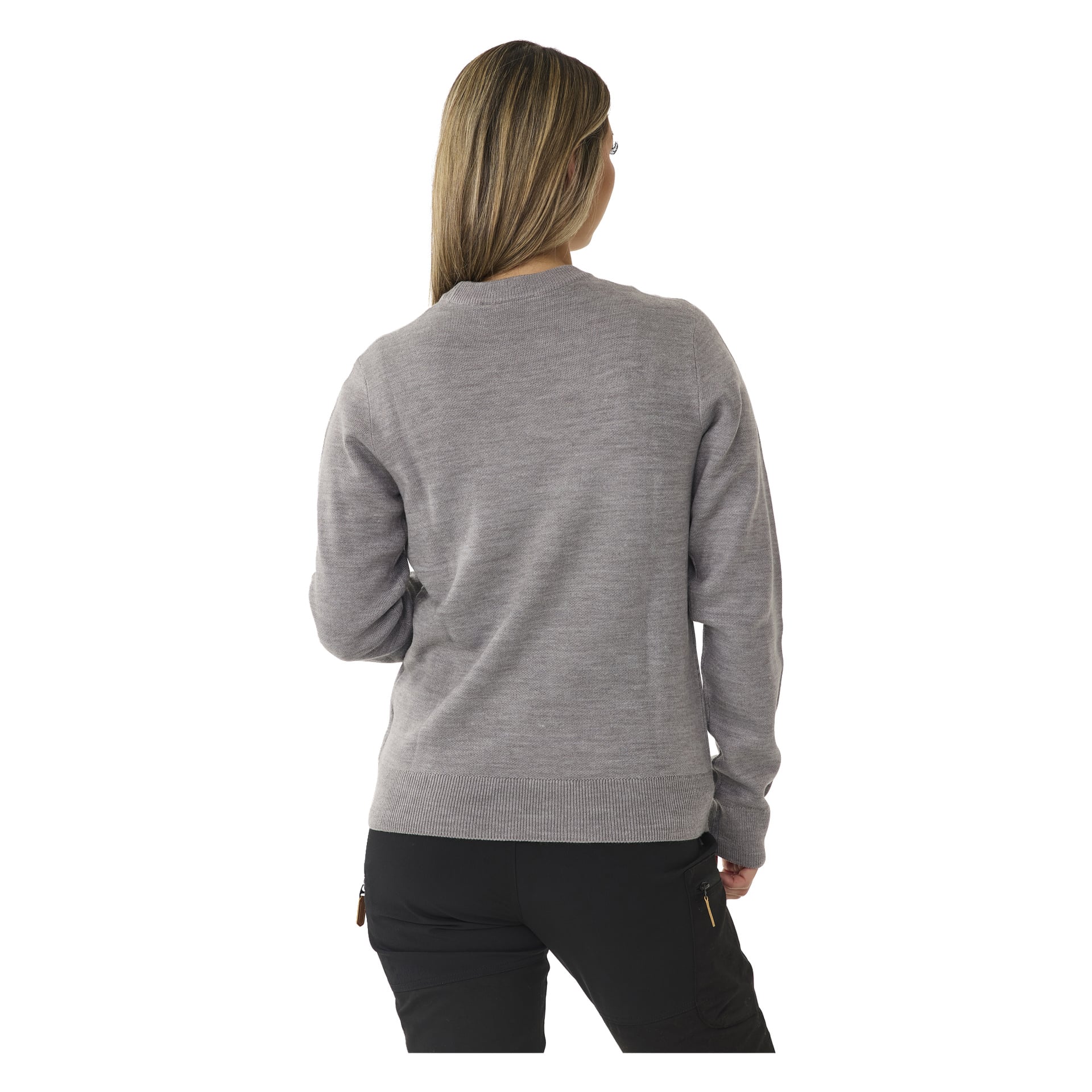 En person med långt, ljusbrunt hår syns bakifrån, klädd i en Bluewear-jultopp och svarta byxor. Deras vänstra arm är böjd och deras huvud vrids lätt åt höger.