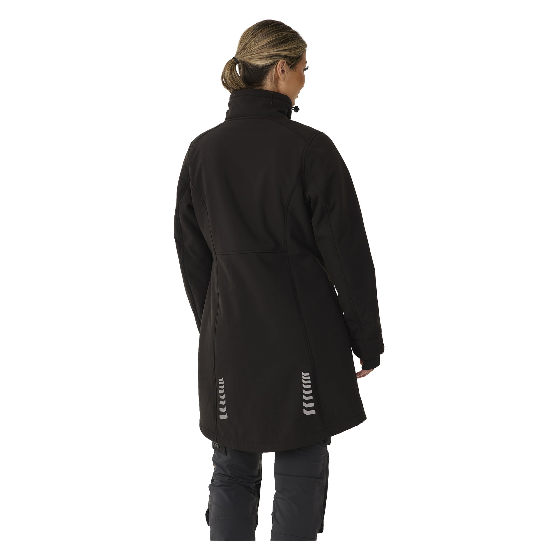 Eine Frau mit blondem Haar, das zu einem tiefen Pferdeschwanz gebunden ist, präsentiert die lange Gunnel-Softshell-Jacke von Bluewear Woman, kombiniert mit dunkler Hose. Sie steht mit dem Rücken zur Schau und zeigt deutlich die Rückseite der Jacke, die zwei reflektierende Streifenakzente am Saum aufweist.