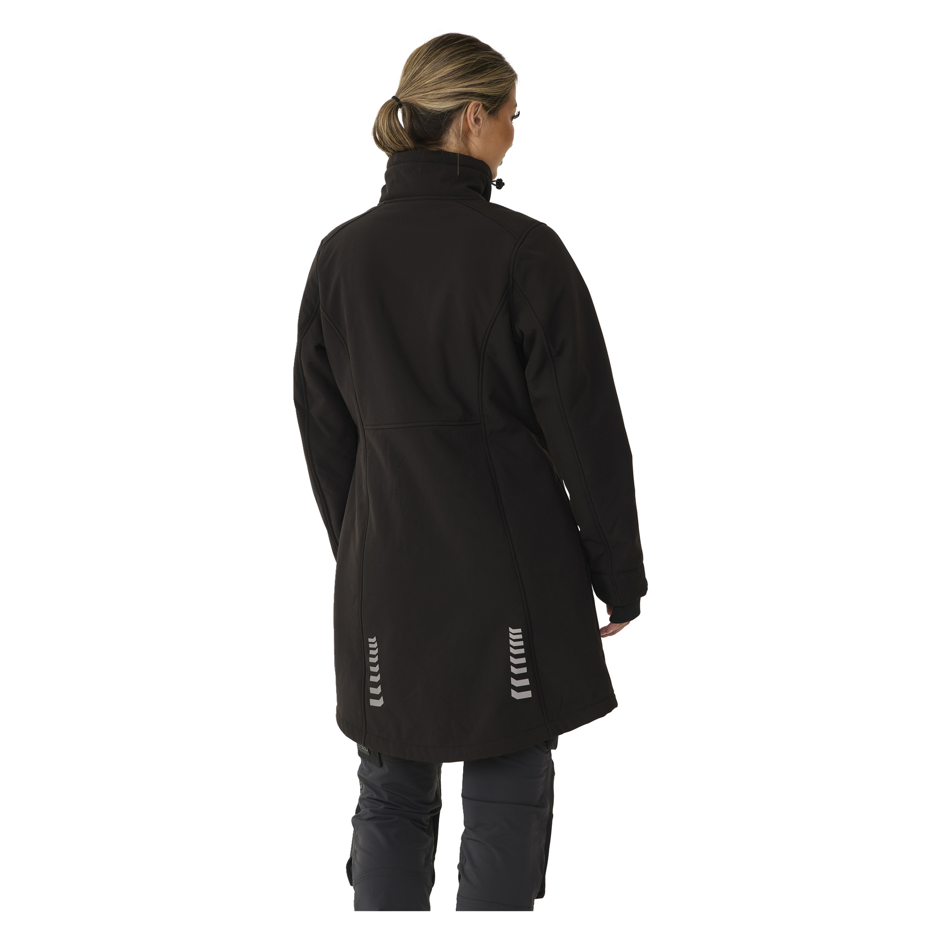 Takaa näkyy vaaleanruskeat hiukset poninhännälle sidottu henkilö, pukeutuneena Bluewear Womanin pitkään Gunnel-softshell-takkiin, jossa on heijastavia yksityiskohtia alaselässä, sekä tummiin housuihin.