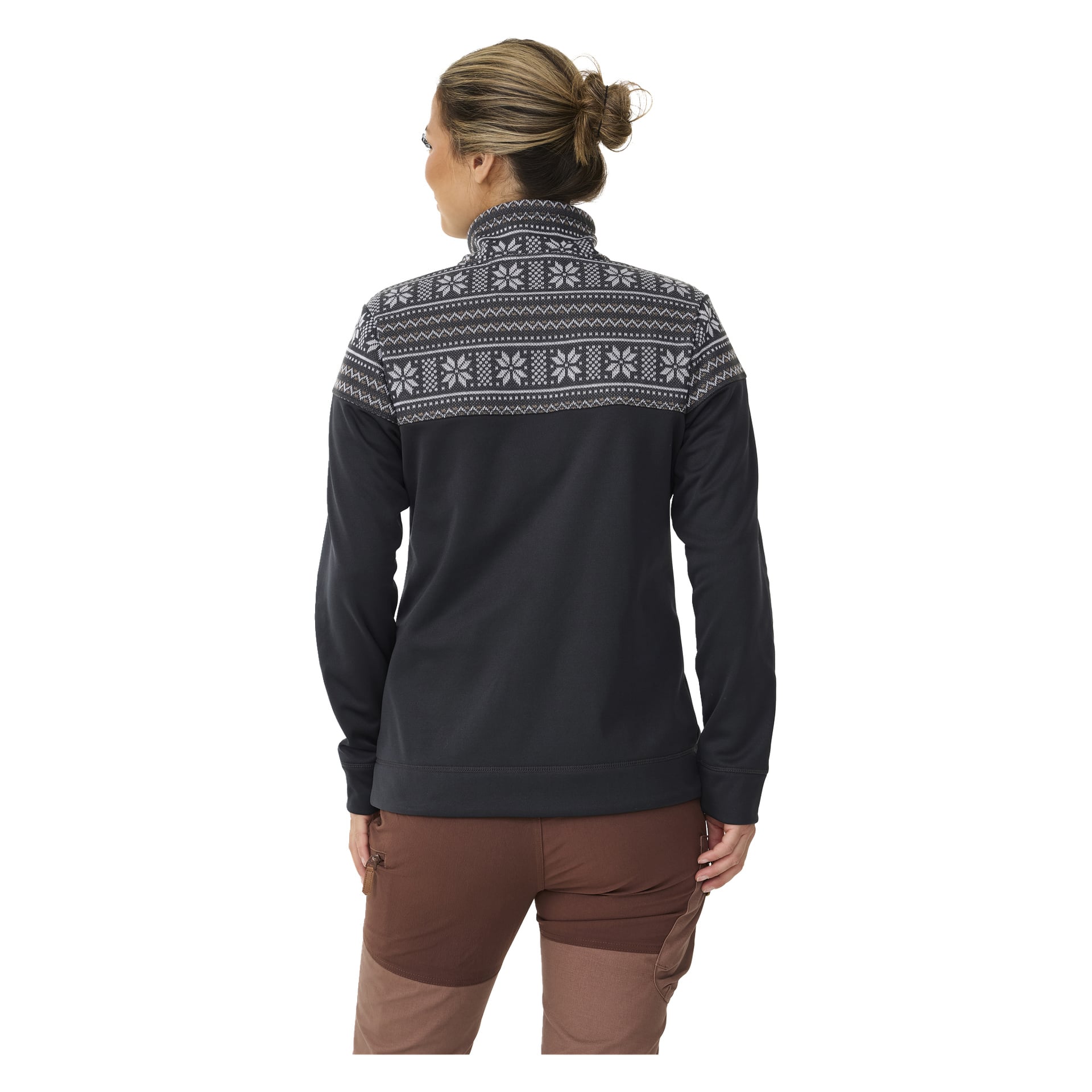 Sett bakifrån bär man Kayoba Outdoor Women's mellanlagers tröja Valbo, som har en mörk bas med ett vitt geometriskt mönster på axlar och övre rygg. De är också klädda i bruna byxor och har håret uppsatt i en knut.