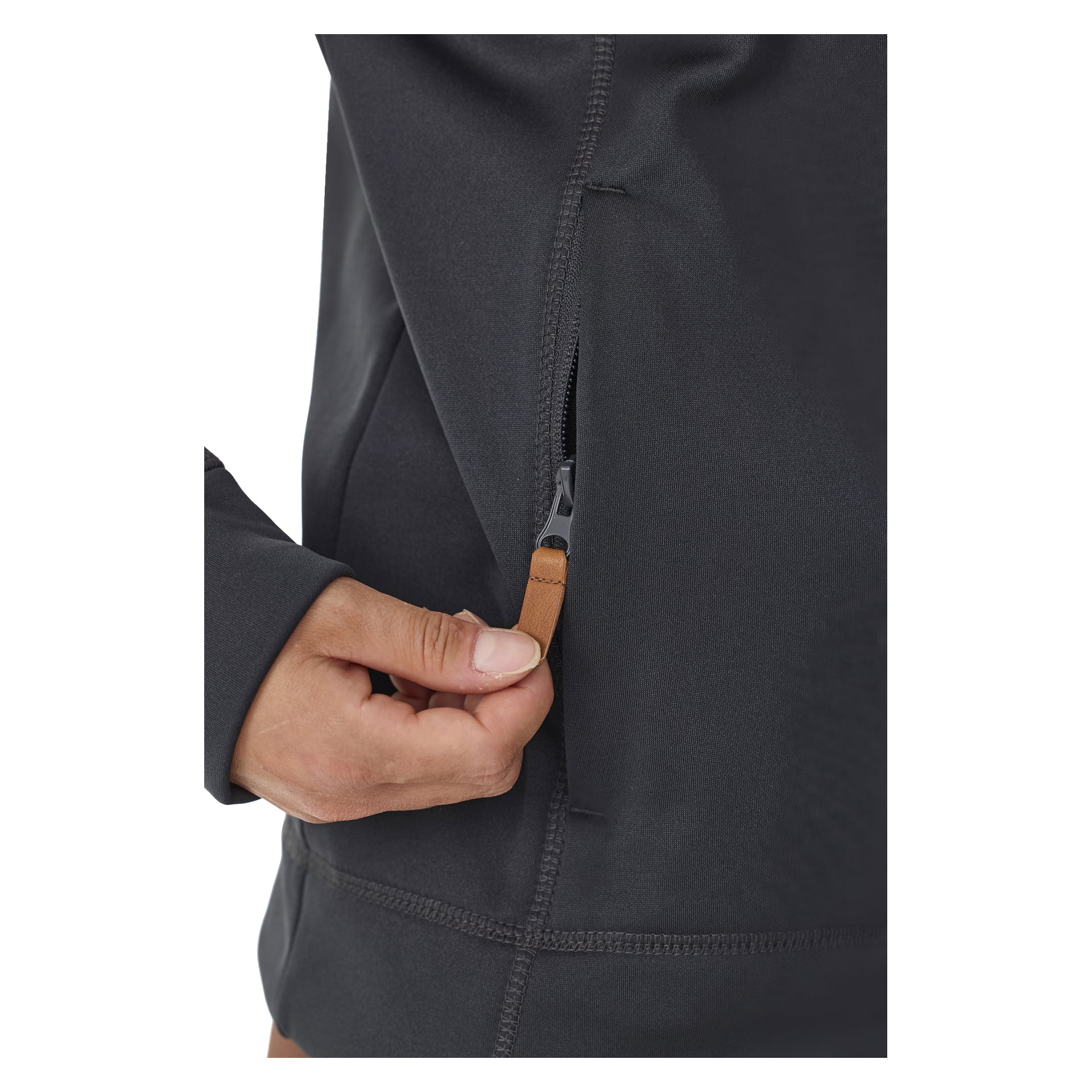 En hand ses dra i en beige dragkedja och öppna sidofickan på en Kayoba Outdoor Women's Valbo mellanlagertröja i mörkgrått. Endast delar av personens hand och tröjan visas.