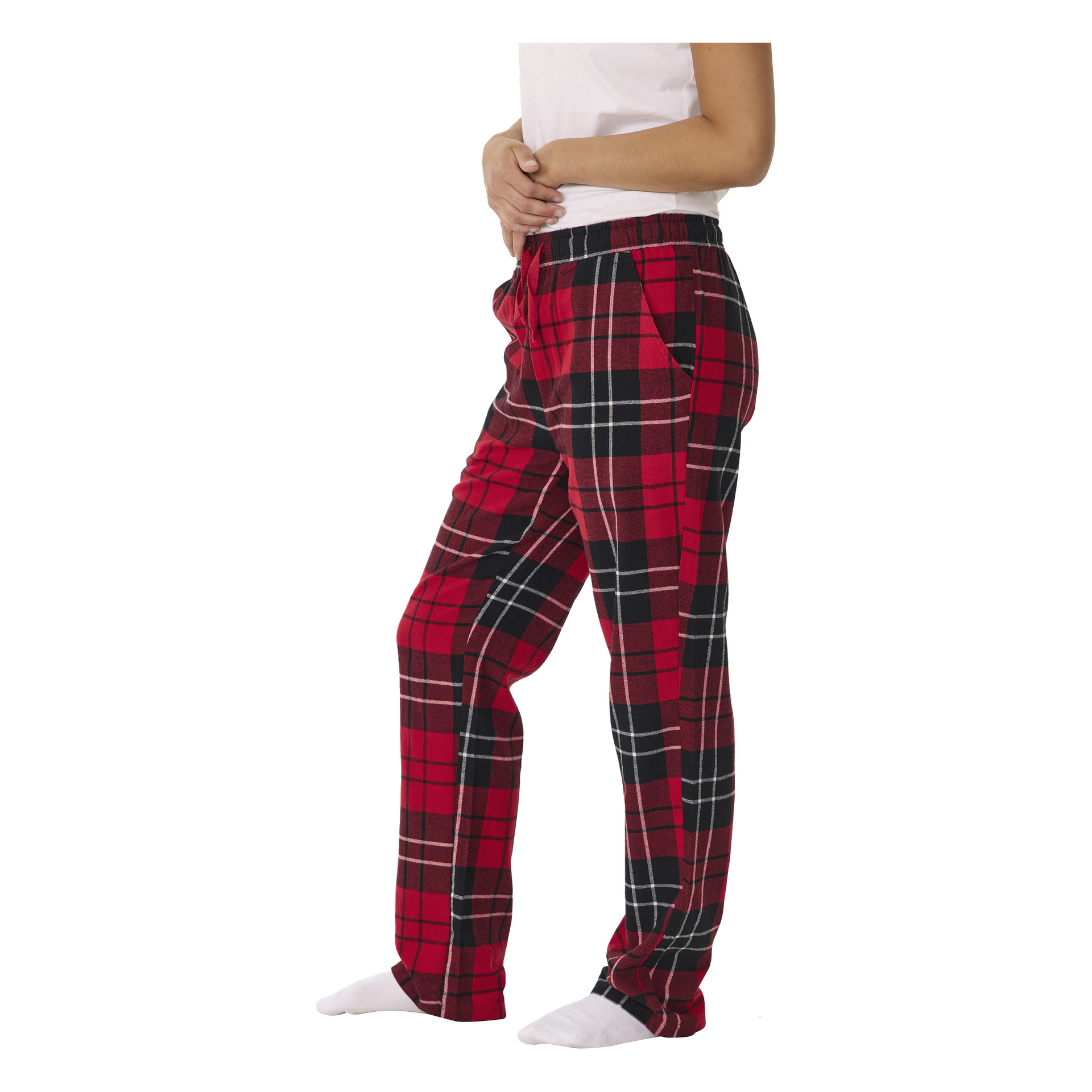 En person visas i profil iklädd Bluewear pyjamasbyxor med röd och svart rutig design, tillsammans med en vit skjorta och vita strumpor. Deras händer vilar på övre delen av buken, och ansiktet är utom synhåll.
