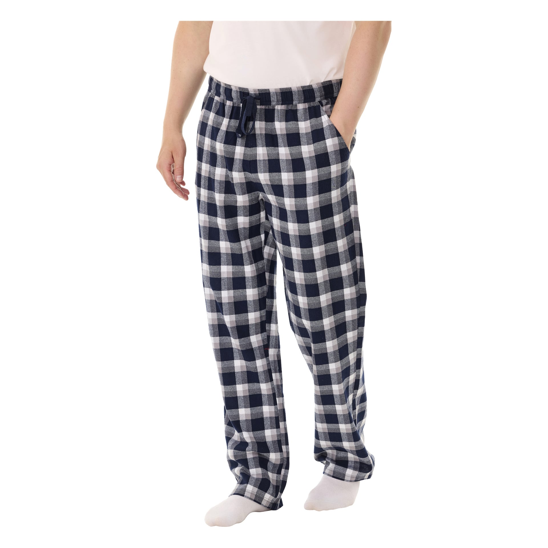 En person modellerar Bluewear-pyjamasbyxor, med ena handen i fickan. Deras ansikte är utanför bild. De bär också en vit skjorta och vita strumpor.