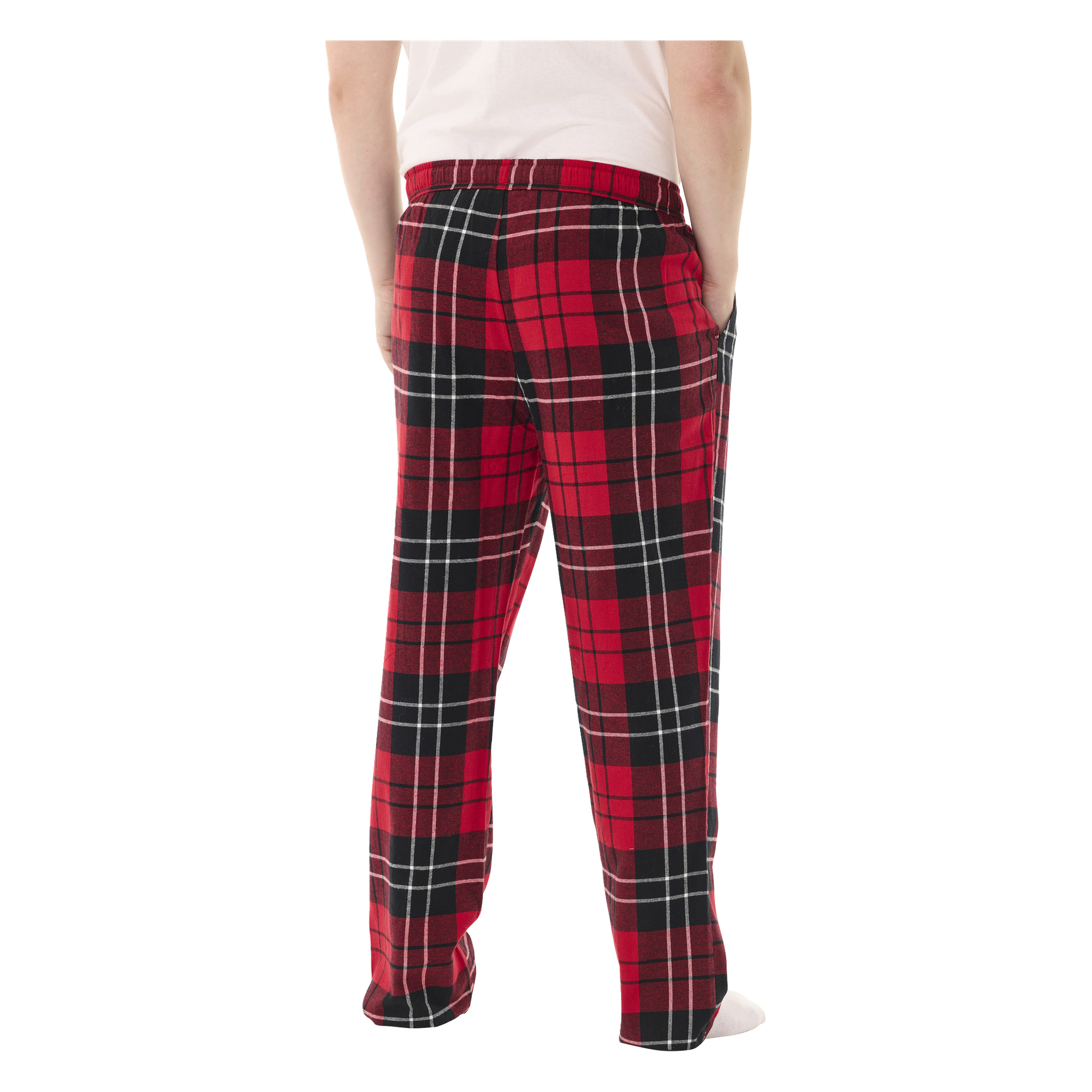 En barfota person står med ryggen mot kameran, händerna i fickorna, klädd i en vit skjorta och röd- och svartrutiga Bluewear pyjamasbyxor.