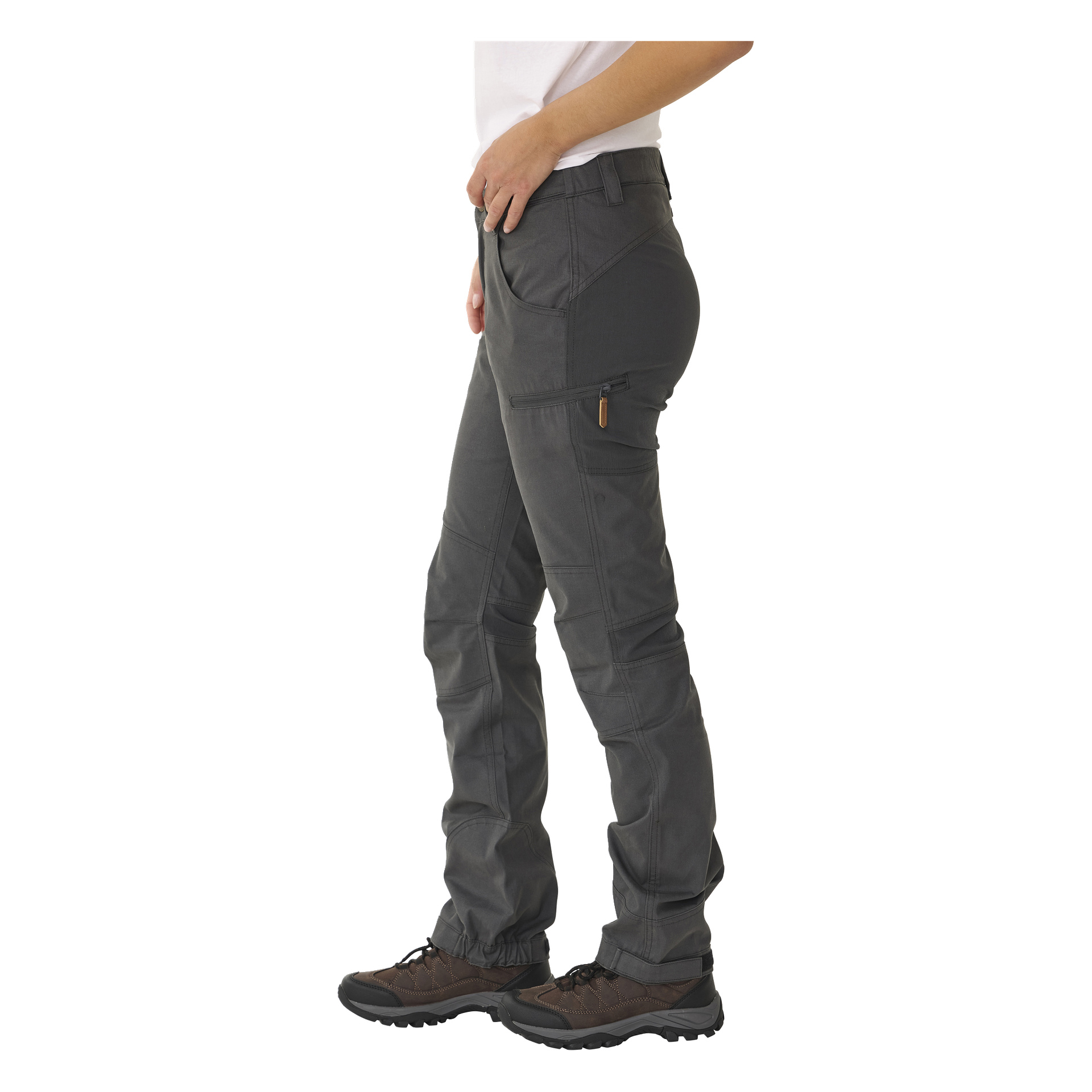 En person står i sideprofil, kledd i hvit skjorte, brune tursko og grå Kayoba Outdoor Leisure-bukser for kvinner, Älvdalen 2.0—cargobukser med glidelåslommer.