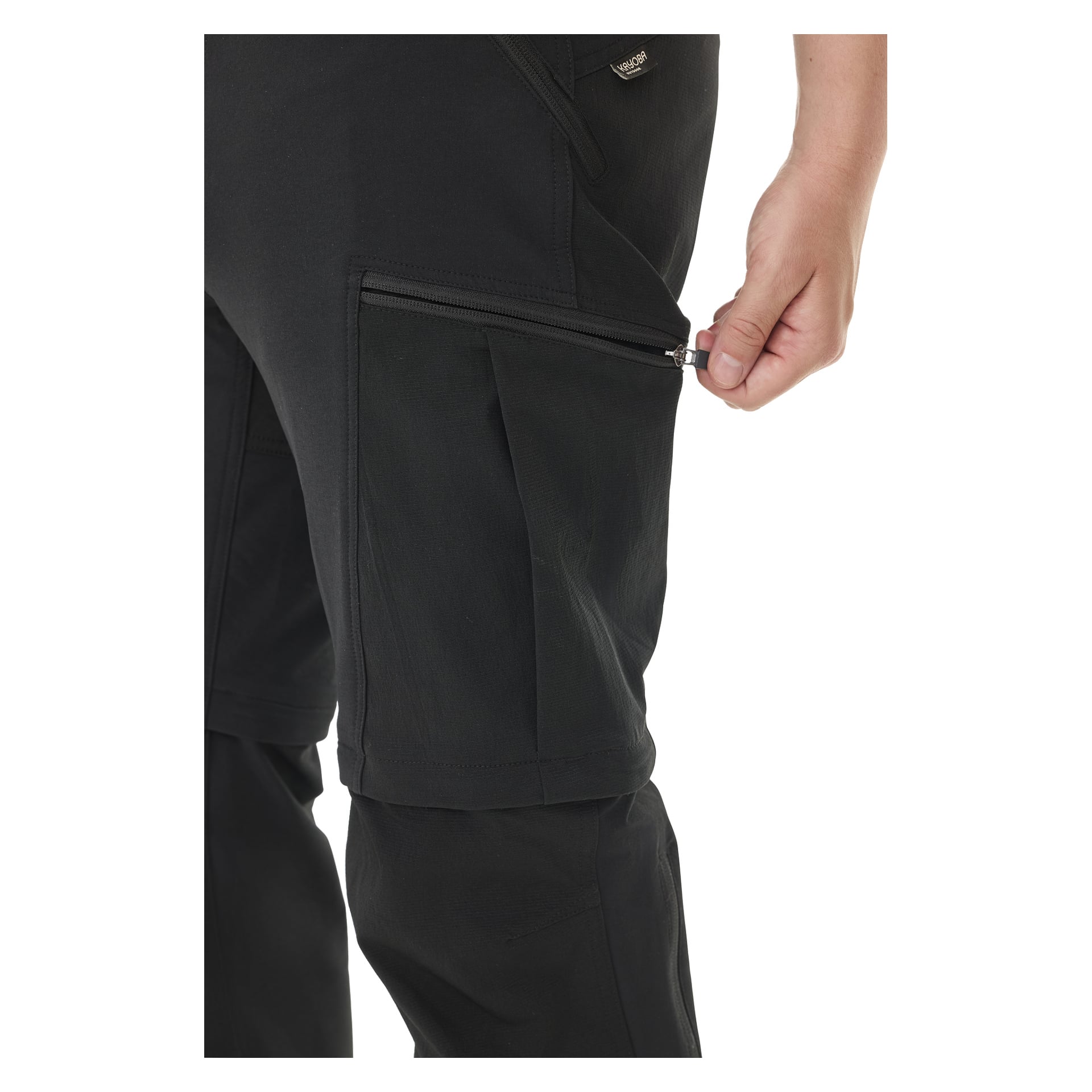 Eine Person wird gezeigt, wie sie die Seitentasche der Herren-Zip-Off Outdoor-Hose Abisko von Kayoba Outdoor öffnet. Der Fokus liegt auf ihrer Hand, dem Reißverschluss und der Tasche, während der Rest der Hose sichtbar ist.