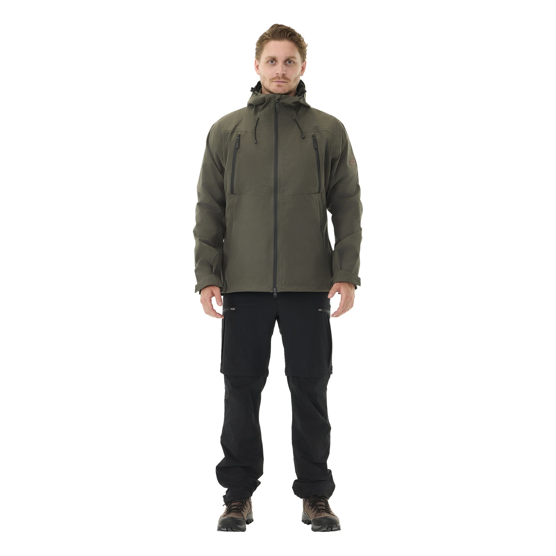 Auf einem Felsen draußen sitzend, öffnet eine Person den Unterschenkelteil ihrer Kayoba Outdoor Herren Abisko-Zip-Hose, wodurch ein Teil des Beins freigelegt wird. Sie sind mit schwarzen Socken, grauen Wanderschuhen und einer dunklen Jacke ausgestattet. Hinter ihnen ist üppiges grünes Gras zu sehen.