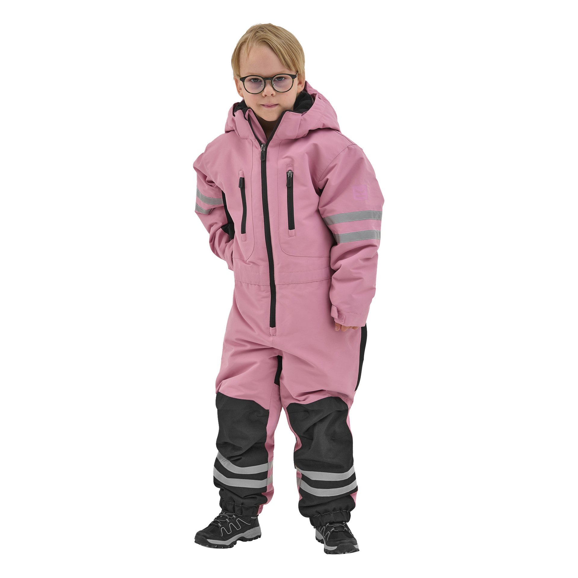 Ett litet barn klädt i en rosa Kayoba Outdoor Dundret hooded snöoverall med grå reflekterande ränder på armar och ben, med glasögon och svarta vinterskor.