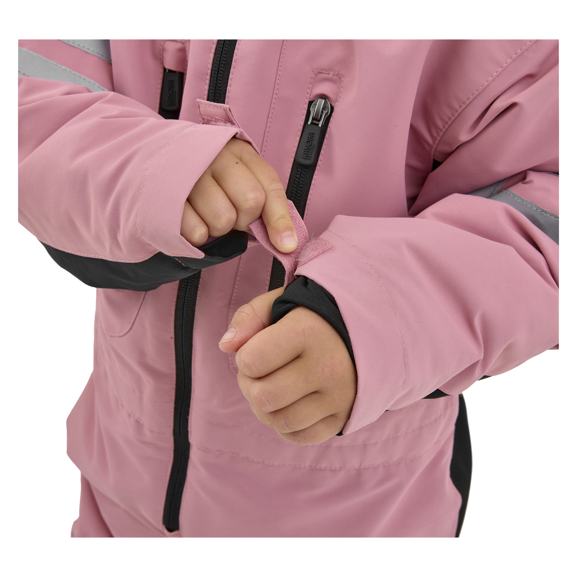 Ett barn, synligt från händerna till bålen, drar åt kardborrebandet på ärmen på en rosa Kayoba Outdoor Dundret-jacka med höger hand. Jackan har svarta detaljer och en framträdande dragkedja fram.