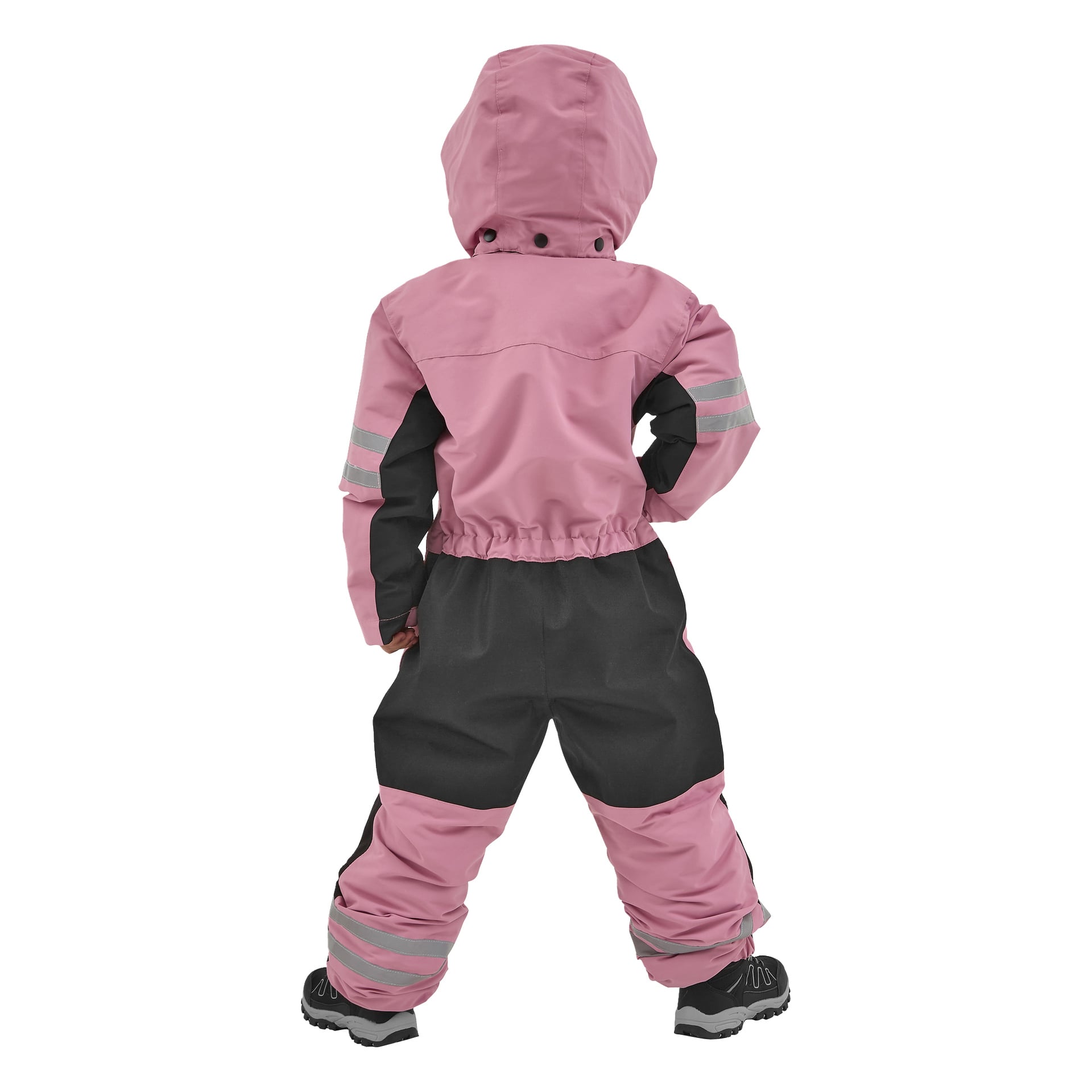 Ett barn, sedd bakifrån med händerna på höfterna, bär en rosa och svart Kayoba Outdoor Dundret hooded snowsuit med reflekterande ränder på ärmar och byxben, samt svarta stövlar.