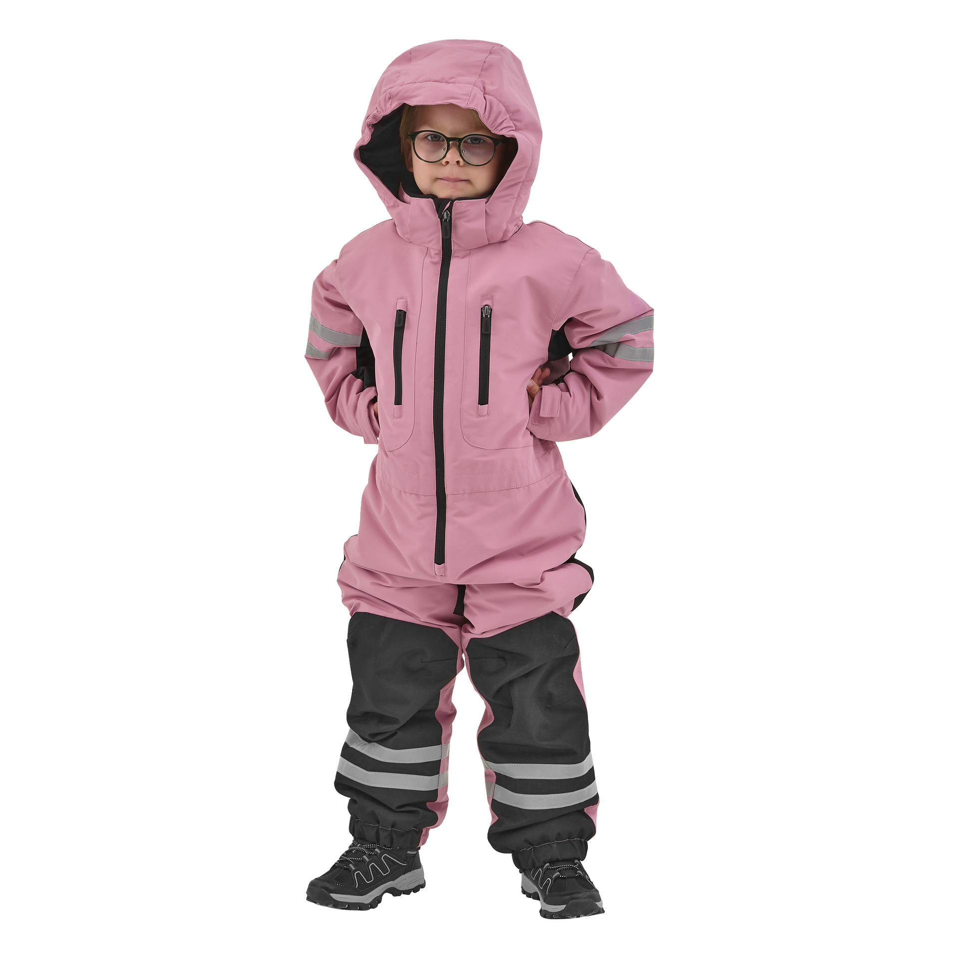 Ett barn med glasögon står självsäkert framåt, händerna på höfterna, klädd i en Kayoba Outdoor Dundret rosa huva med svarta byxor och reflekterande ränder.