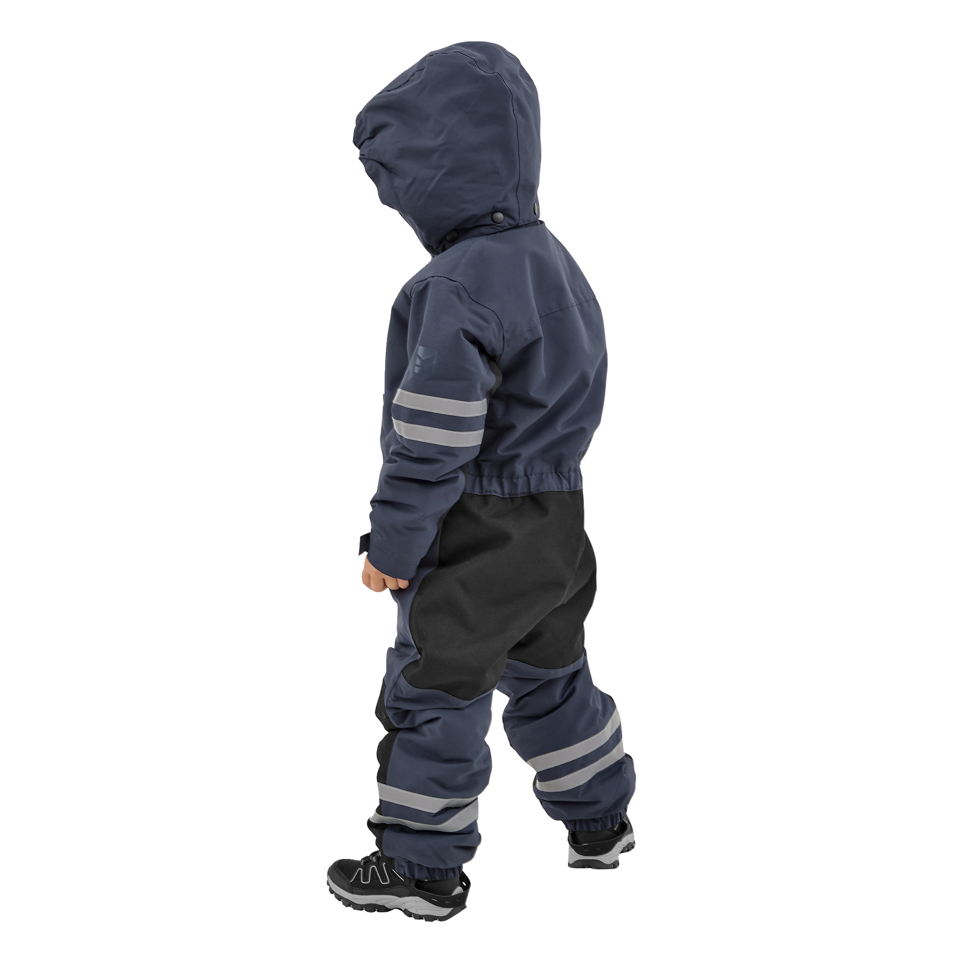 Ett barn syns bakifrån, klädd i en marinblå och svart Kayoba Outdoor Dundret hooded regndräkt med reflekterande ränder, tillsammans med svarta sneakers med vita sulor.